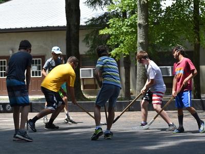 teens playing street hockey at Rambling Pines Day Camp