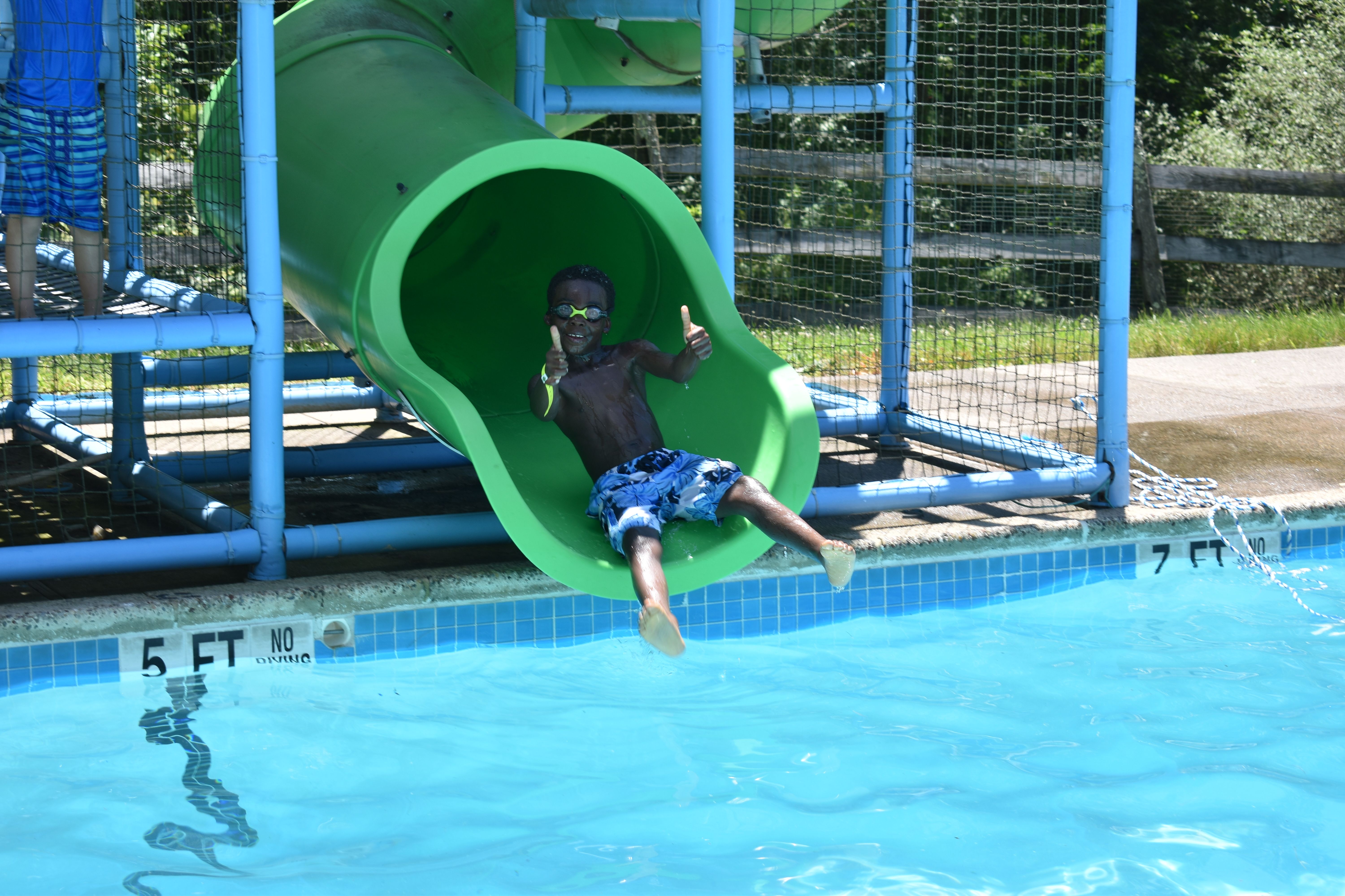 camper going down a water slide at Rambling Pines Day Camp