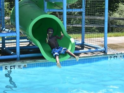 camper going down a water slide at Rambling Pines Day Camp