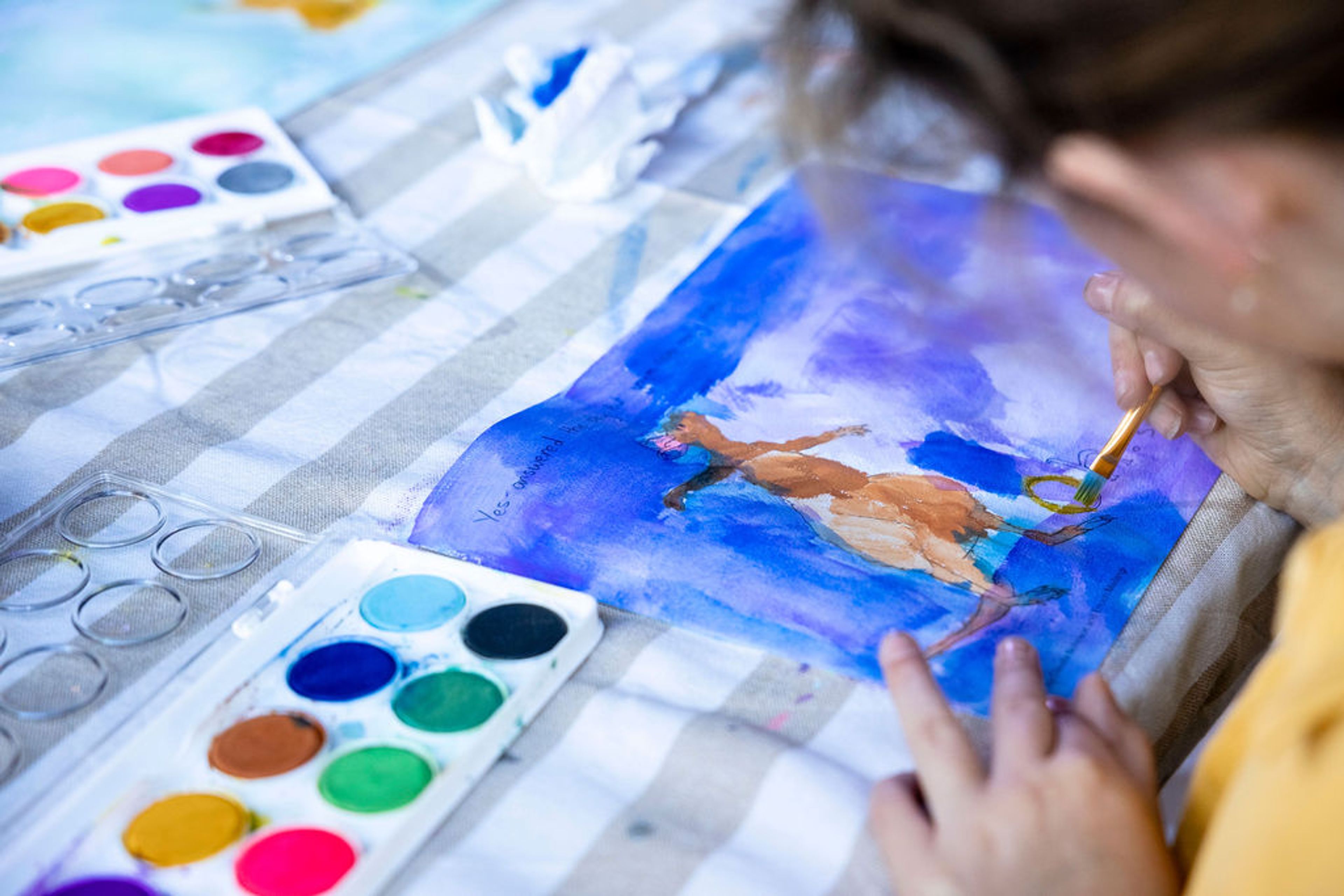 A school child works on a watercolour painting
