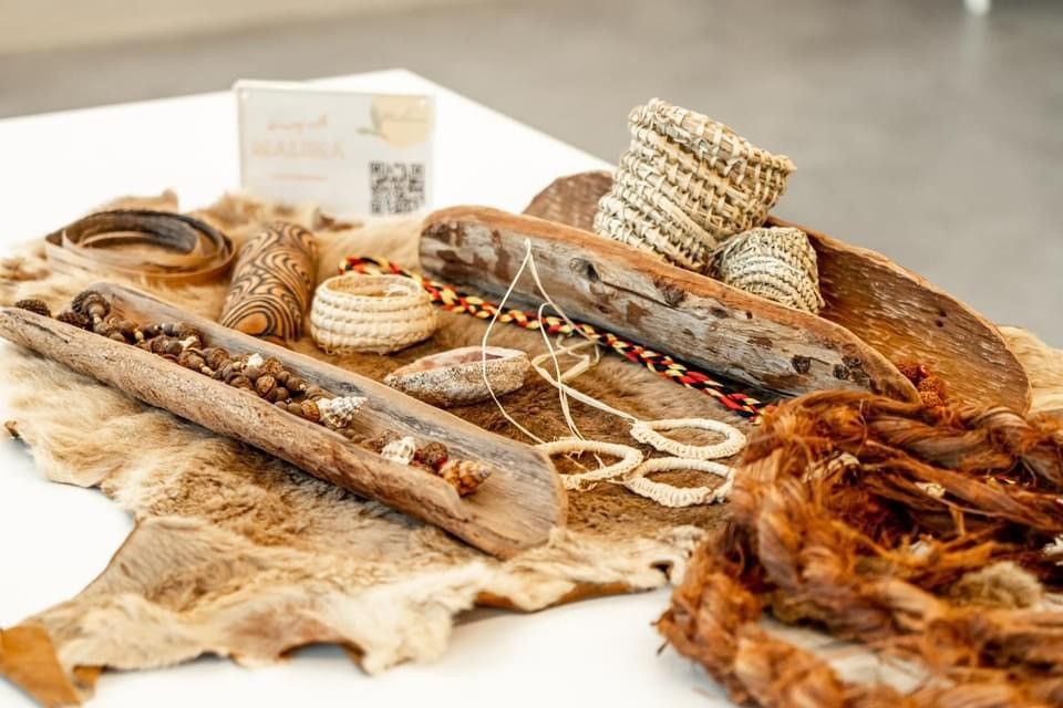 Aboriginal weaving and crafts displayed on a kangaroo skin rug.