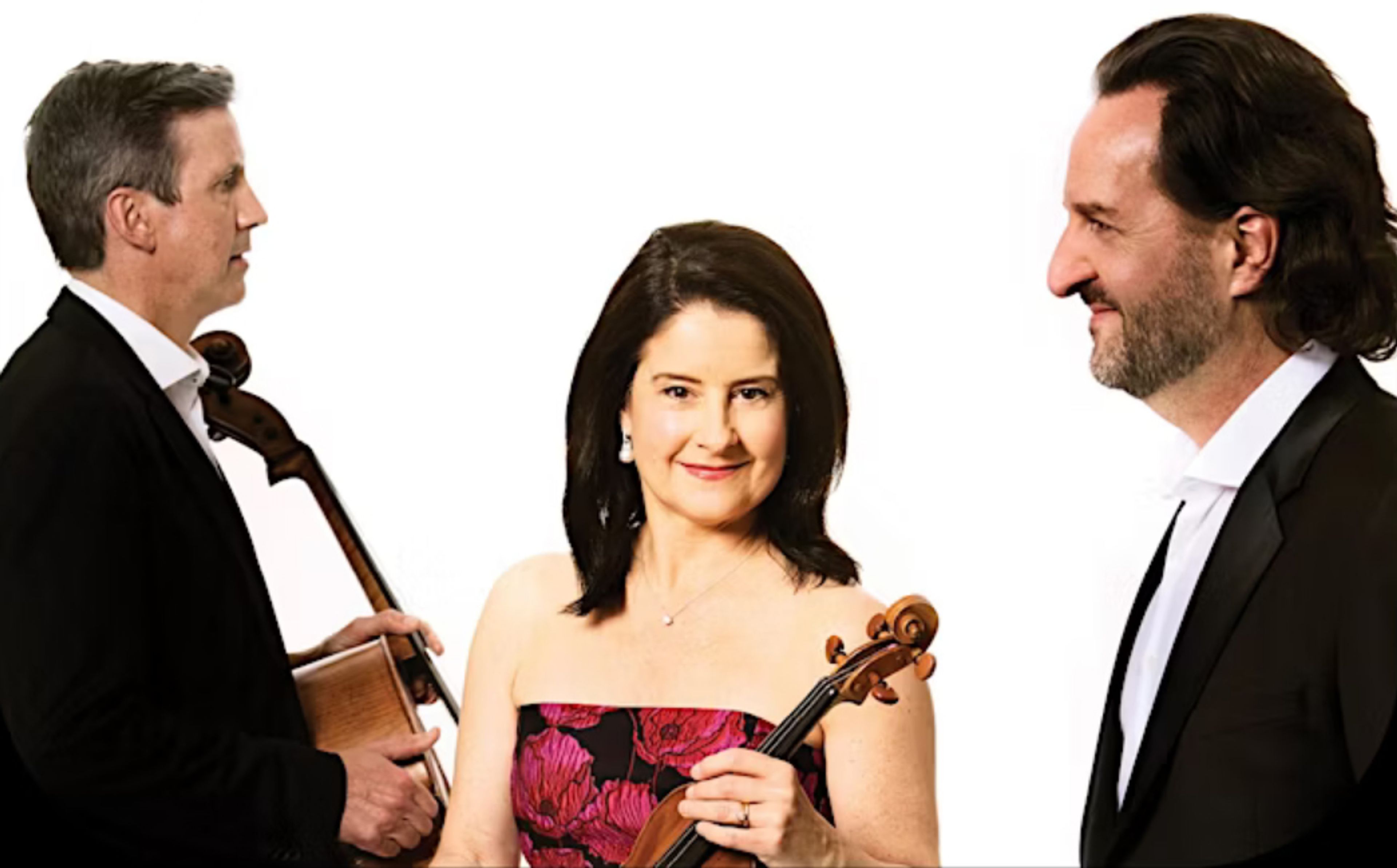 Three concert performers stand with their instruments