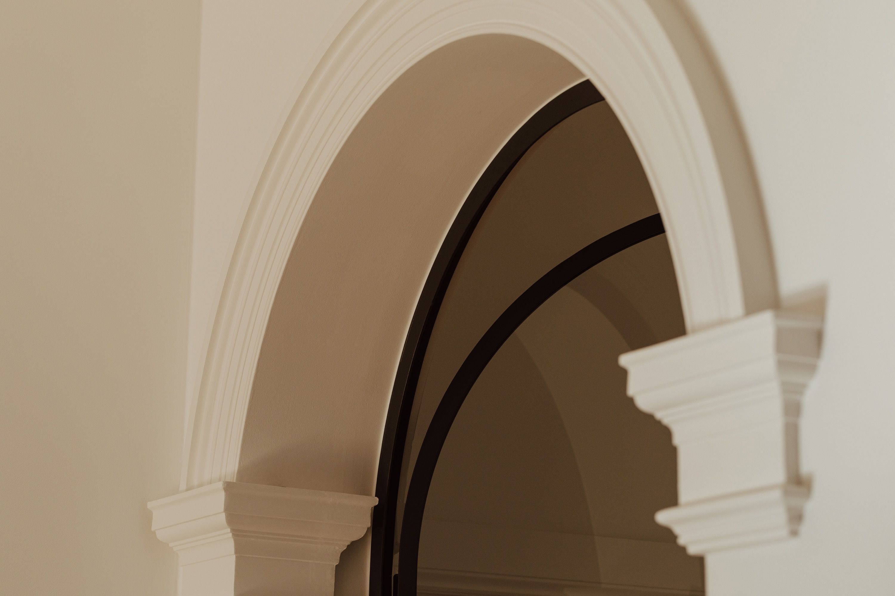 Classical plaster arch with black steel doorway — RESLU, Adelaide