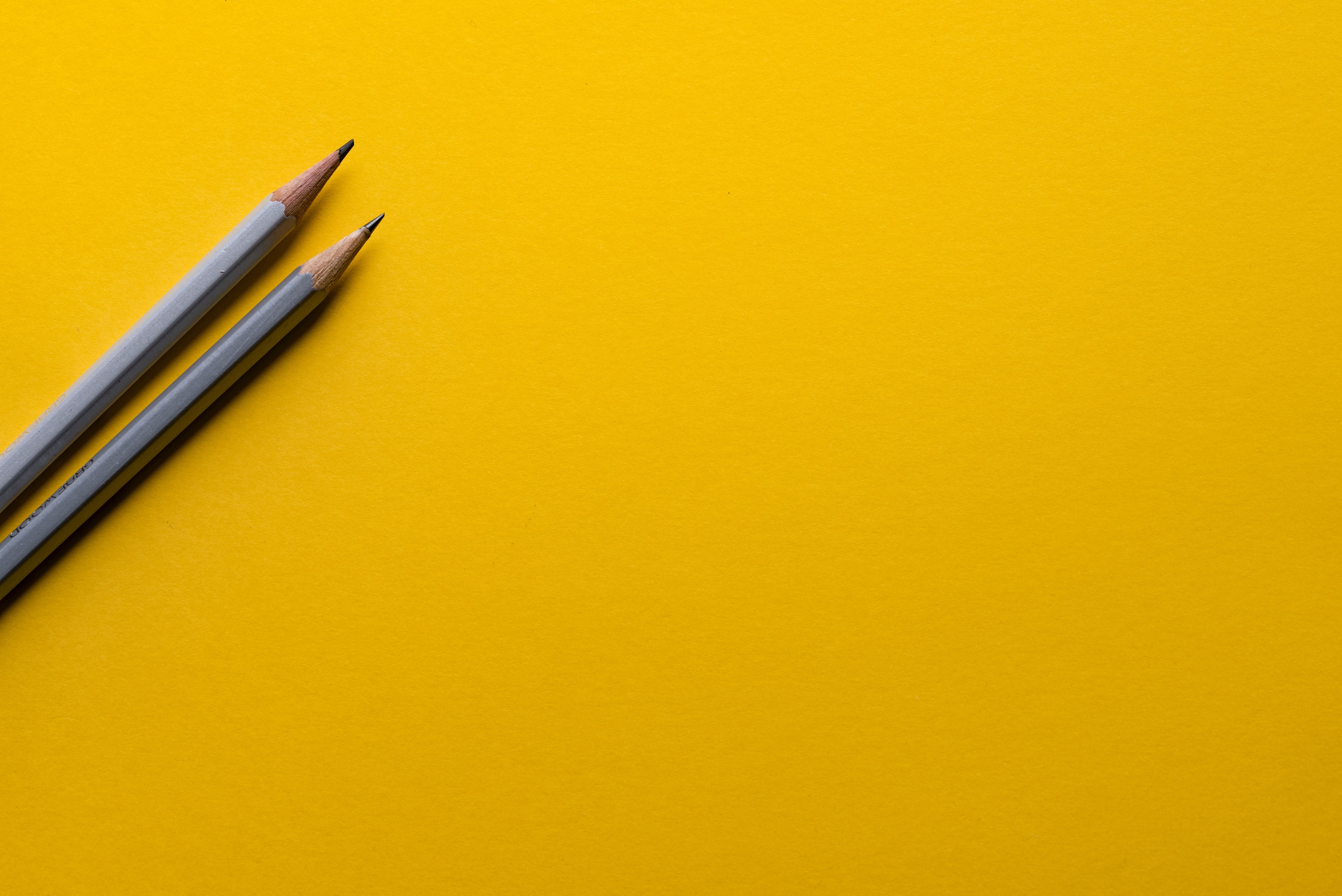 Image of grey pencils on yellow background