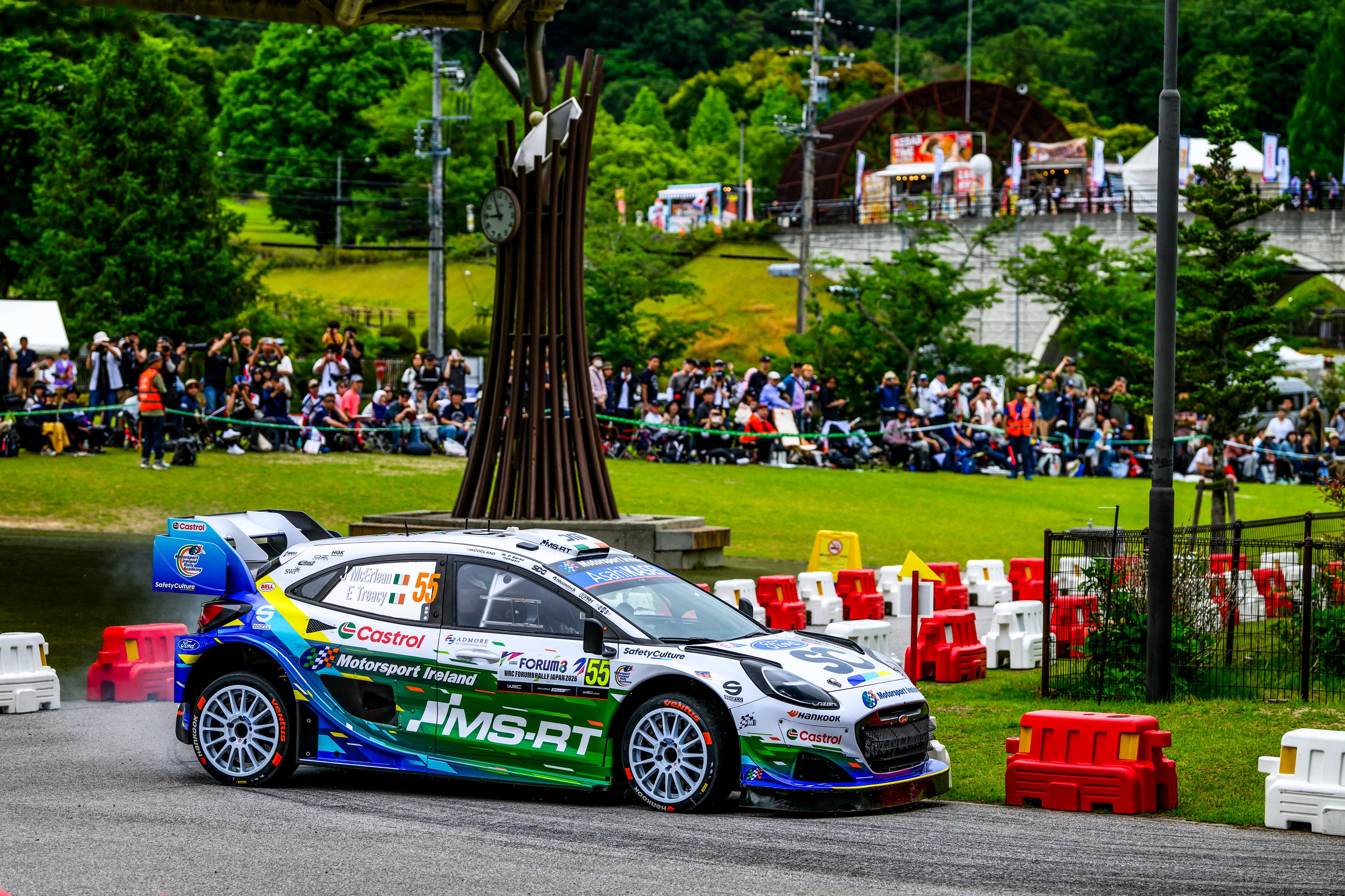 Castrol-sponsoreret rallybil fra Motorsport Ireland drifter gennem et sving foran tilskuere ved WRC Rally Japan
