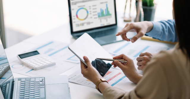 invoicing systems on laptops one person tapping on a smart tablet