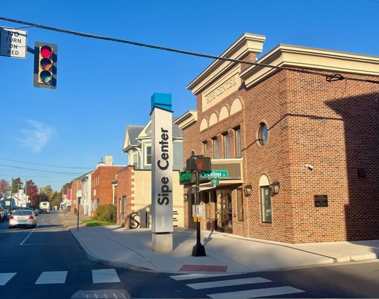 street corner of a small town with two story buildings and a traffic light
