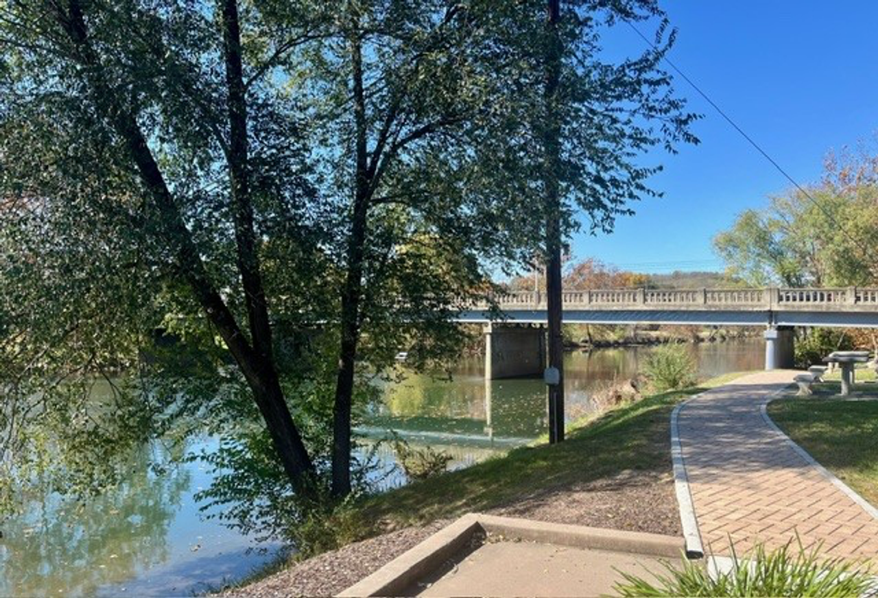 outdoor walkway next to a river showing a bridge