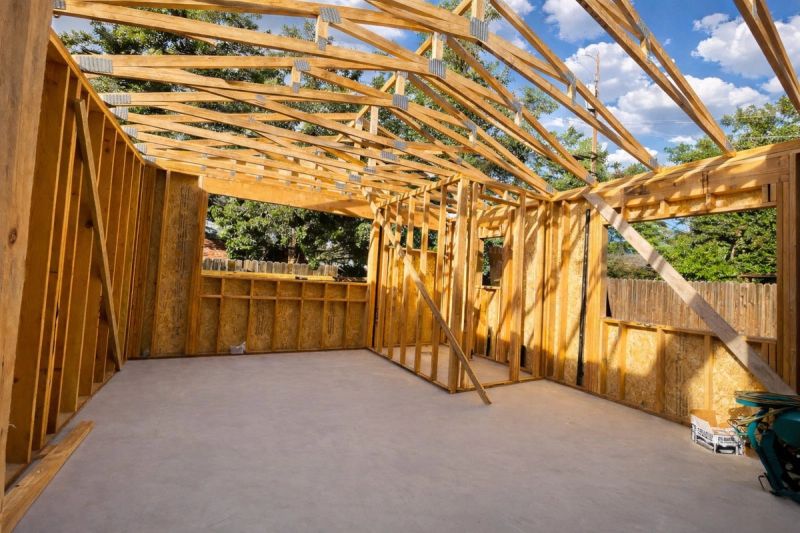 Interior view of a backyard ADU framed with custom roof trusses showing open ceiling structure and wall framing before sheathing by Mike Walker Lumber Co Inc