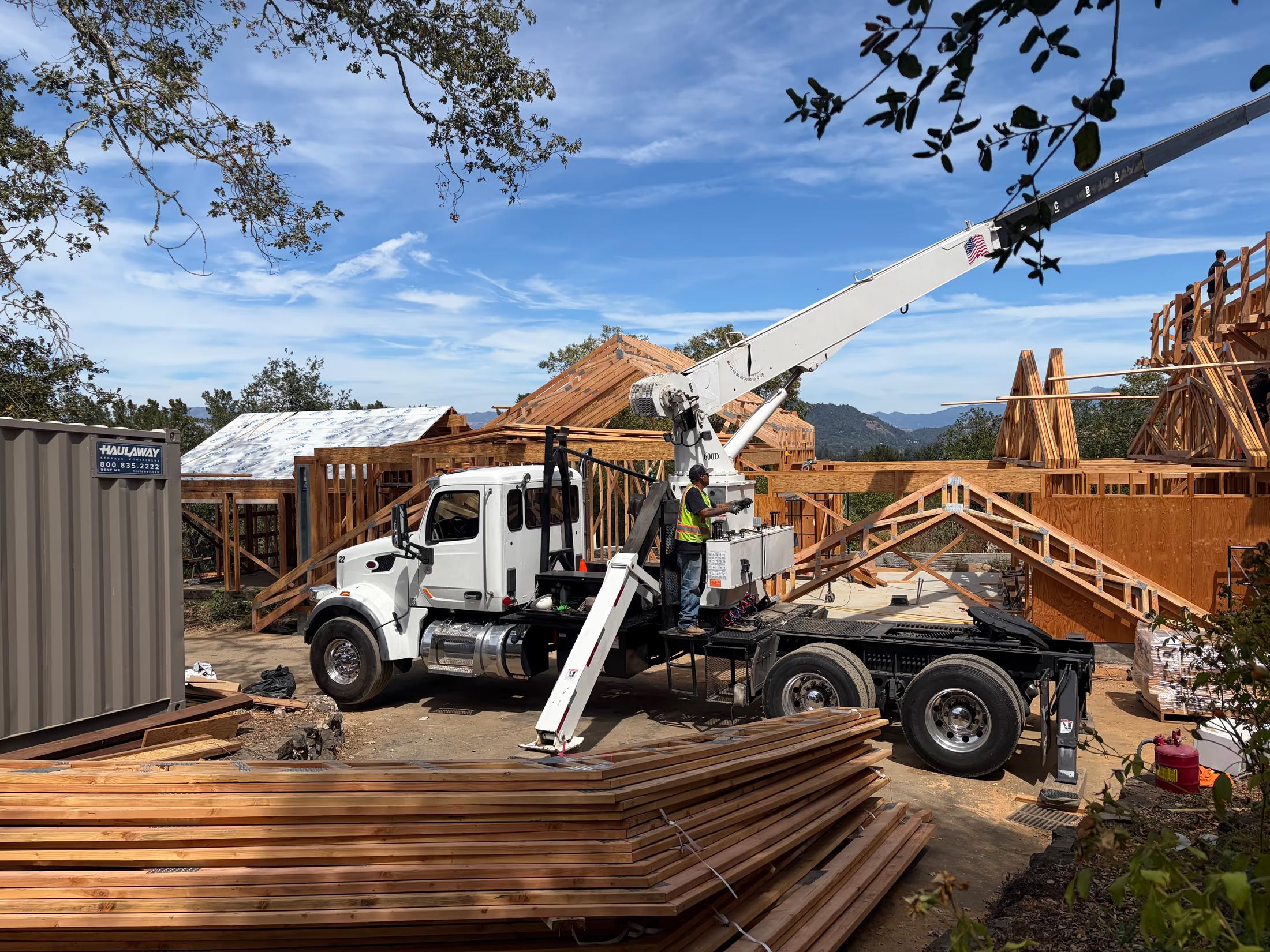 Crane truck staged in the driveway with the truss package