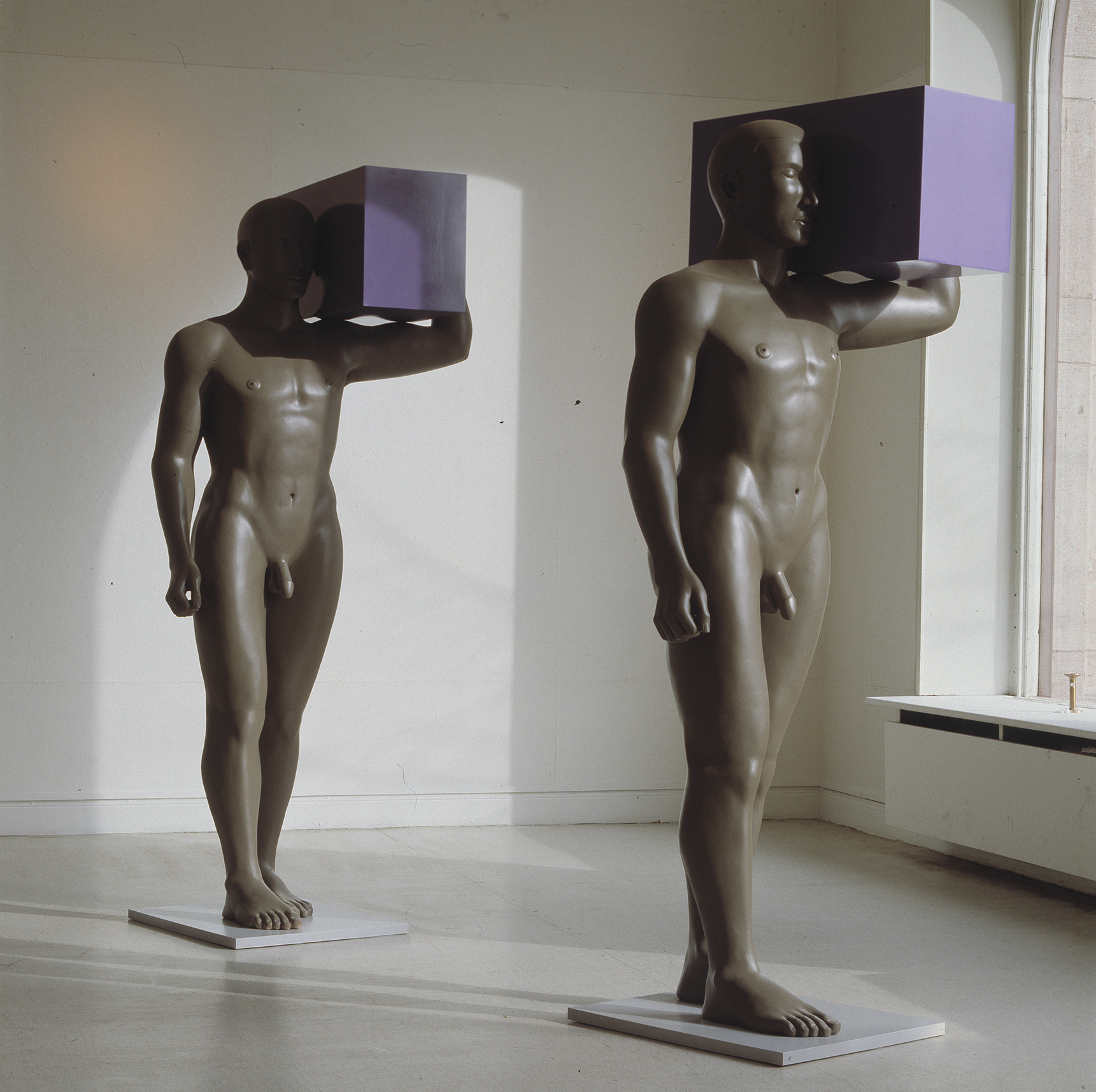 Two sculptures of men holding boxes