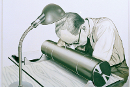 Man sitting by a desk with a cylinder