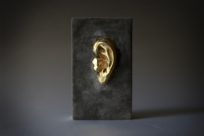 statue of a grey brick with a golden ear