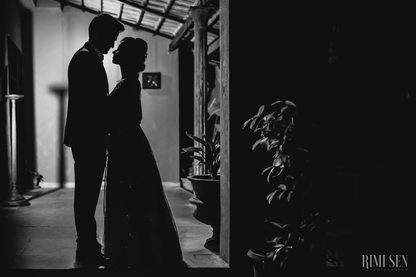 Pooja and Aniket embrace in silhouette under moody industrial lighting, Bangalore by Rimi Sen