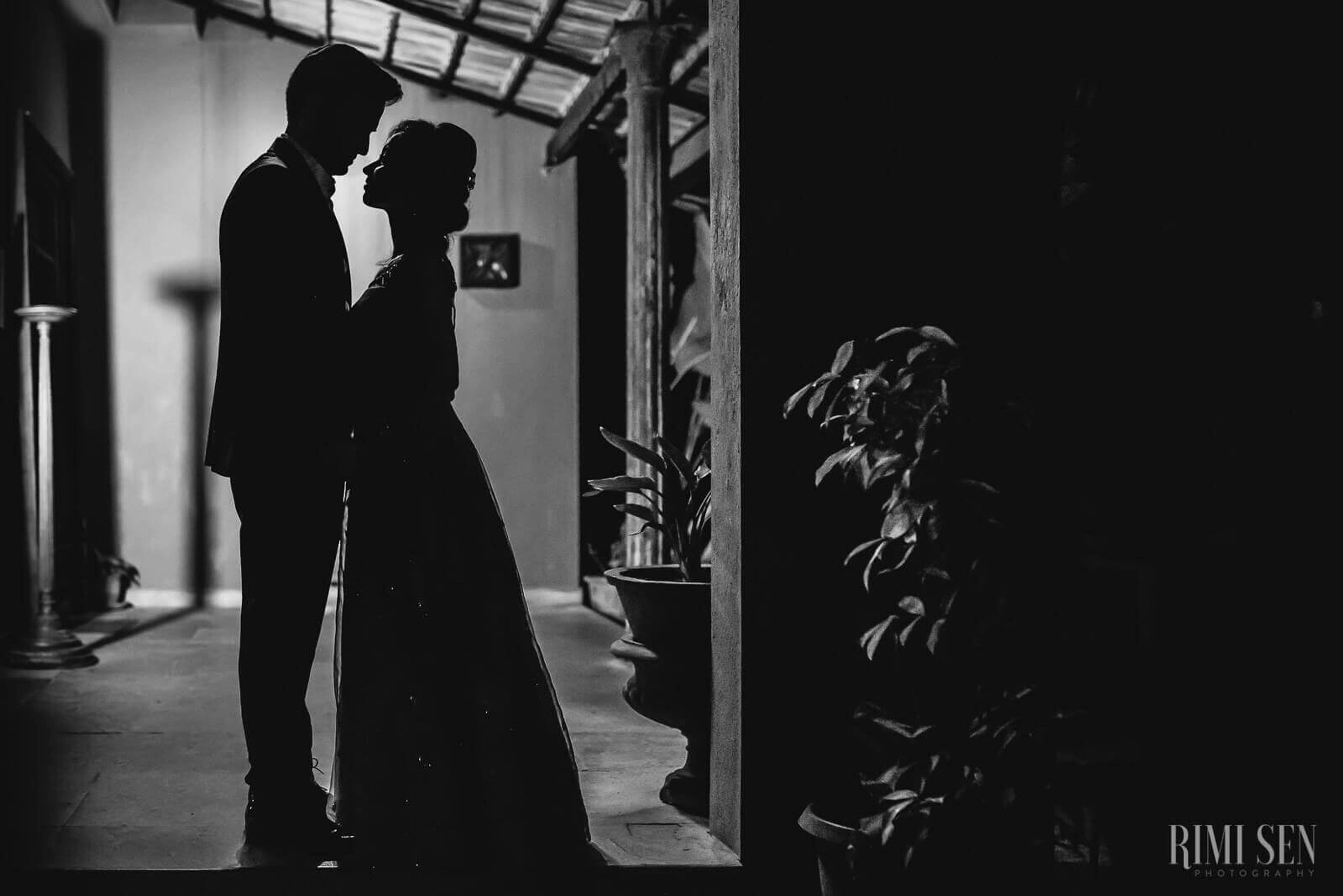 Pooja and Aniket embrace in silhouette under moody industrial lighting, Bangalore by Rimi Sen