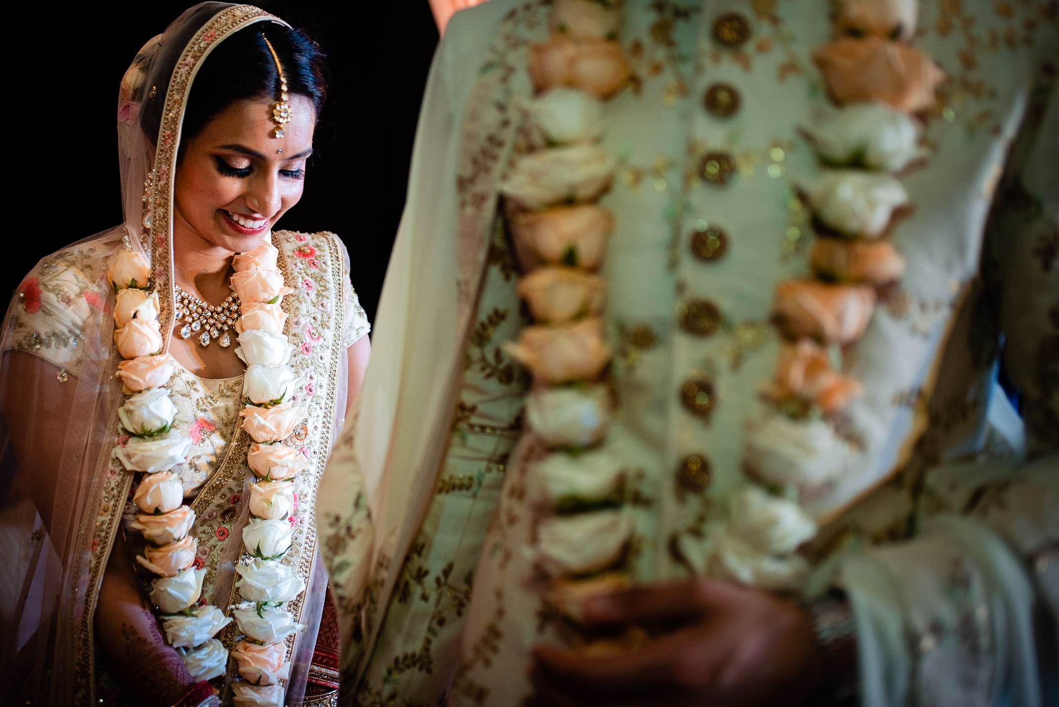 Avani smiles wearing traditional wedding attire with floral garlands and ornate jewelry in Goa