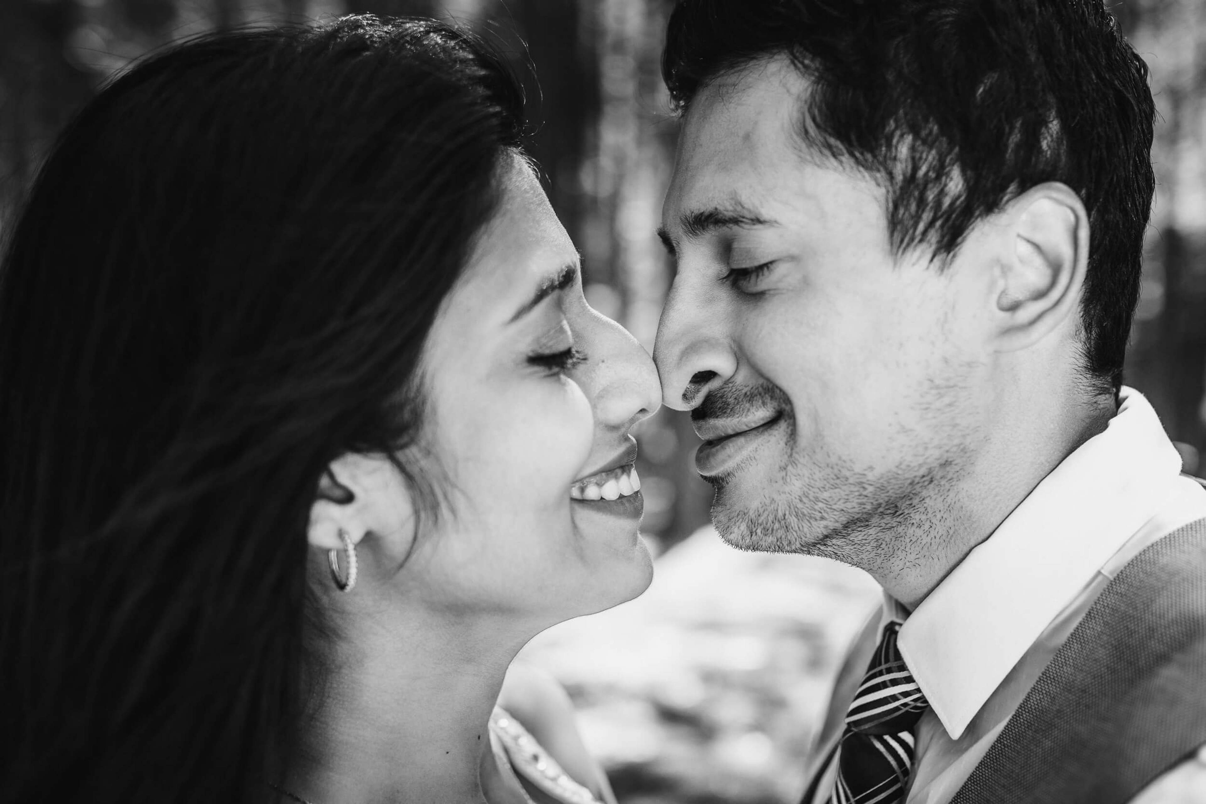 Anu and Raghu share an intimate close-up moment, both smiling, in black and white
