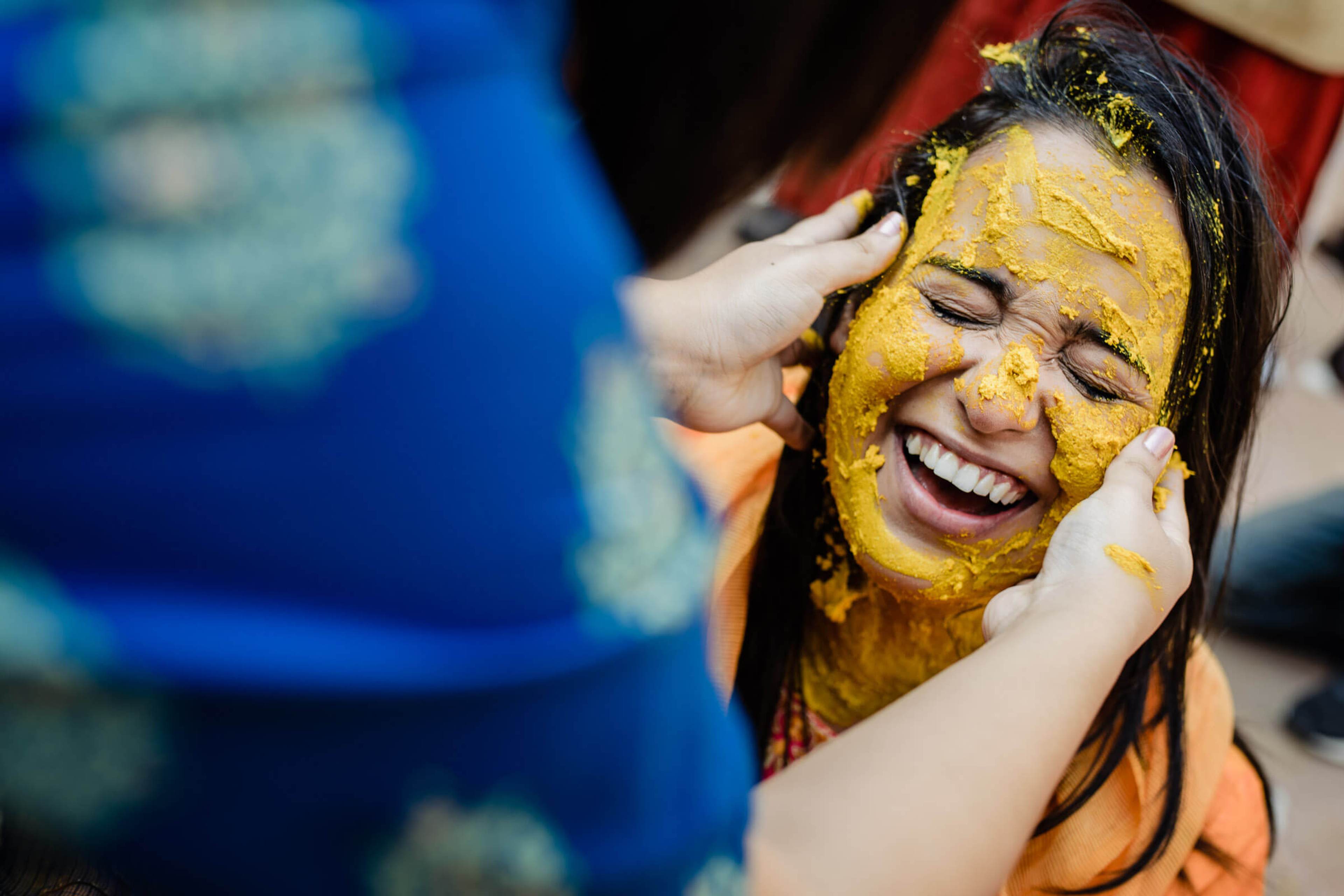 Maitrayee laughs joyfully with golden turmeric paste applied to her face during Haldi ceremony in Rajasthan
