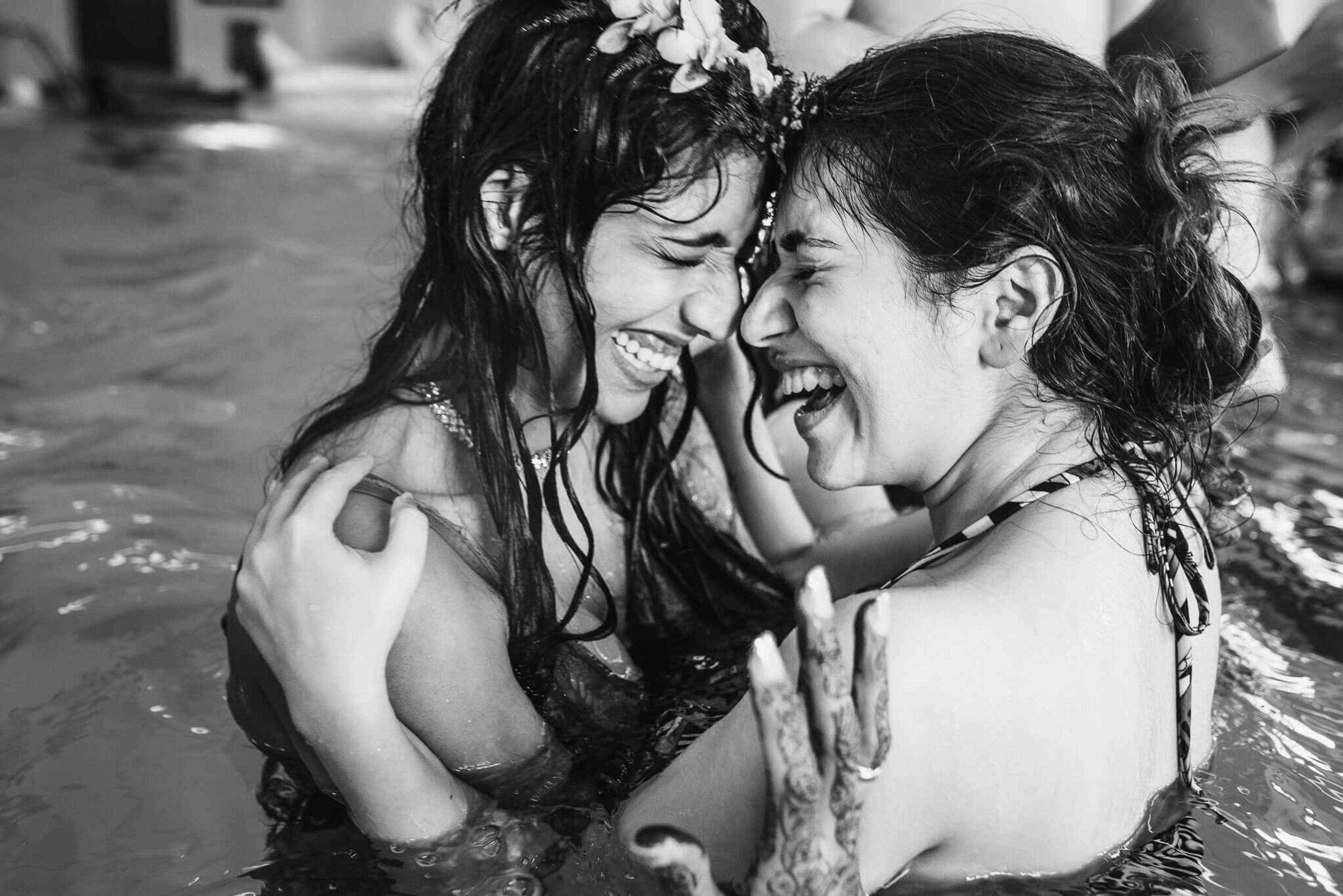 Anu and Raghu laugh together in water, wet hair and mud, intimate moment in black and white