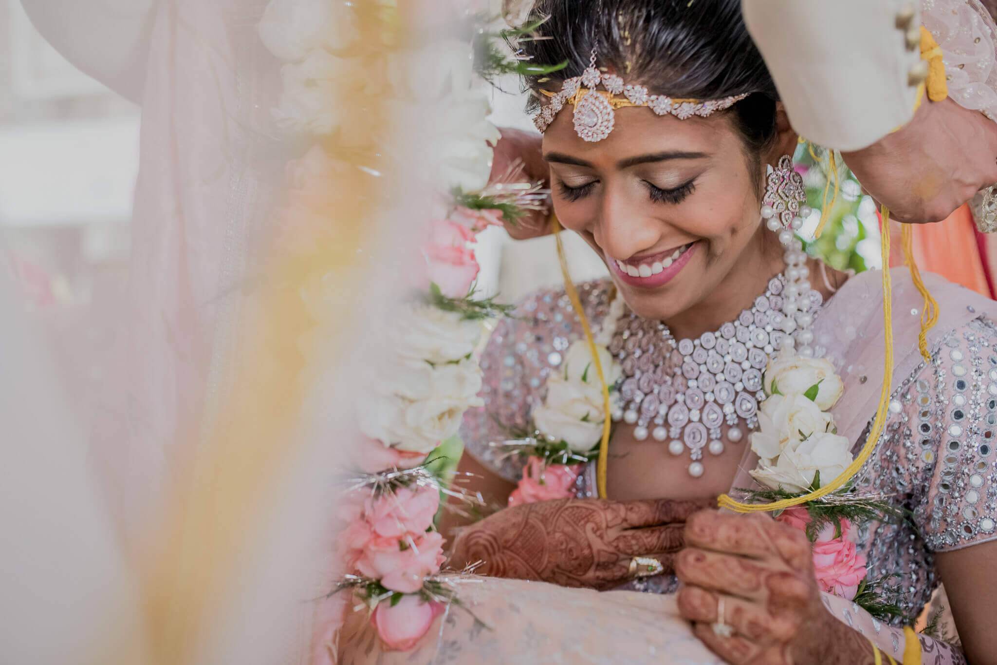 Anu smiles wearing ornate jewelry and floral garland during wedding ceremony in Nepal