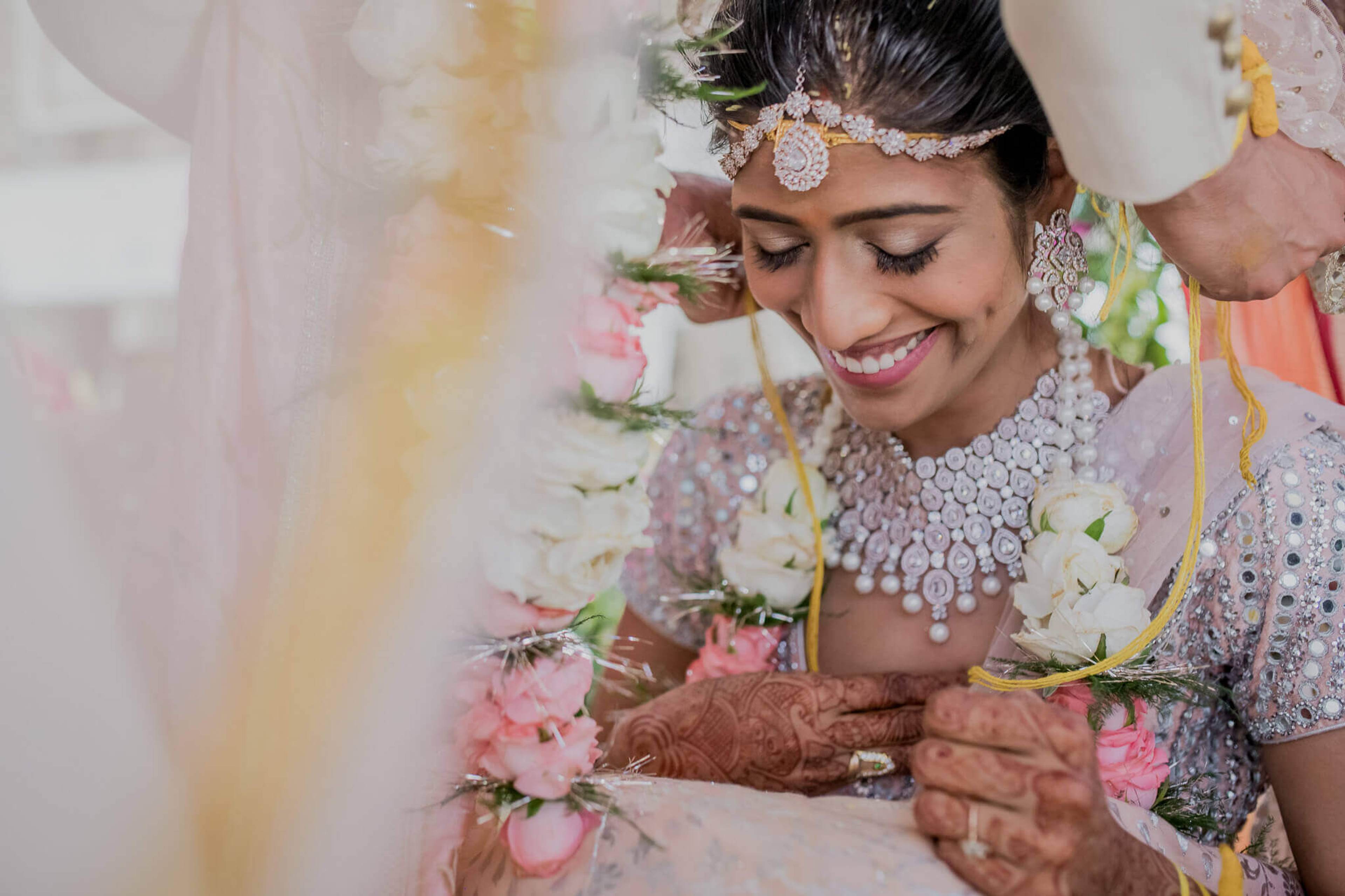 Anu smiles wearing ornate jewelry and floral garland during wedding ceremony in Nepal