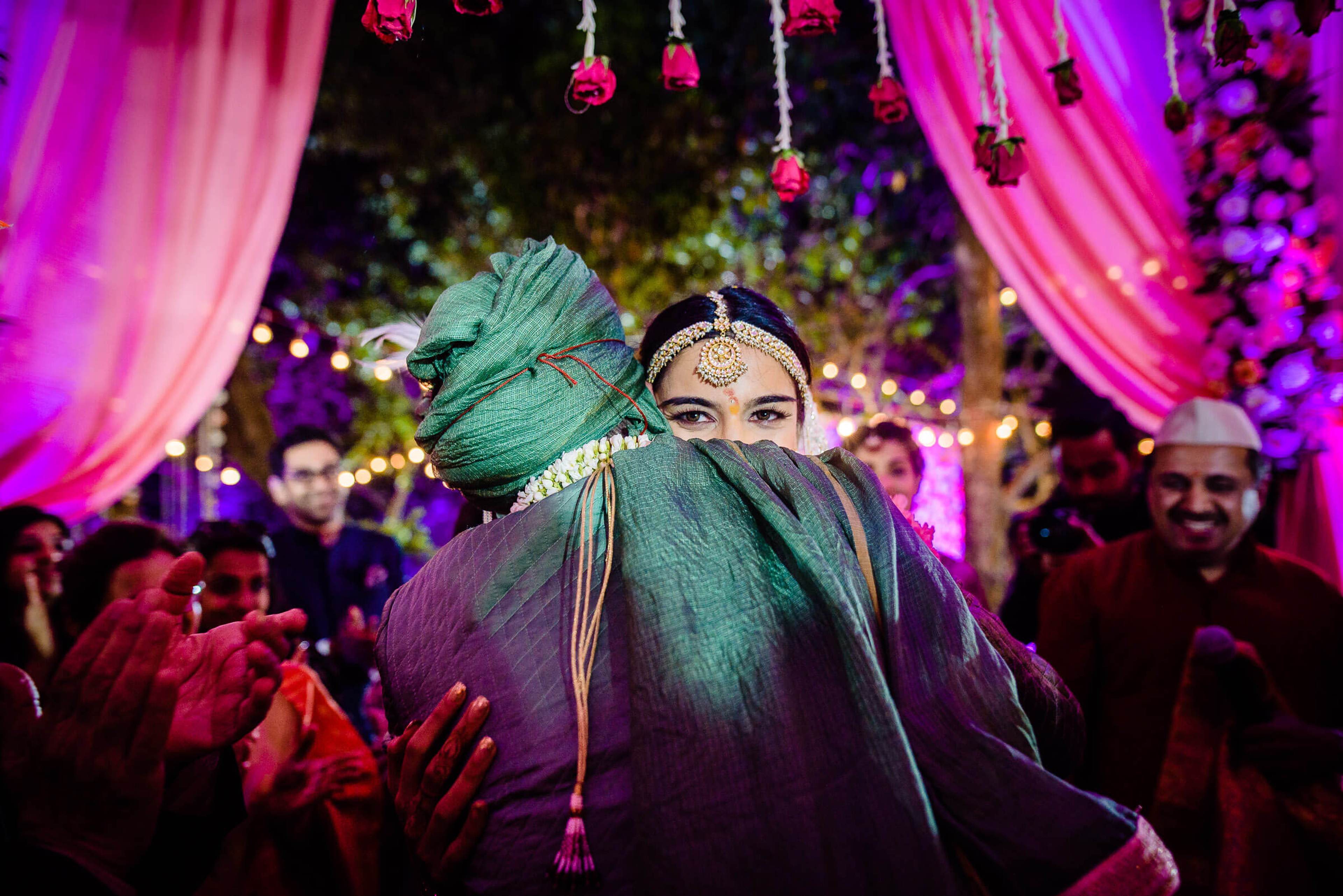 Shreya in teal turban and forehead jewelry dances with Yash at Mahabaleshwar celebration, vibrant pink drapes overhead