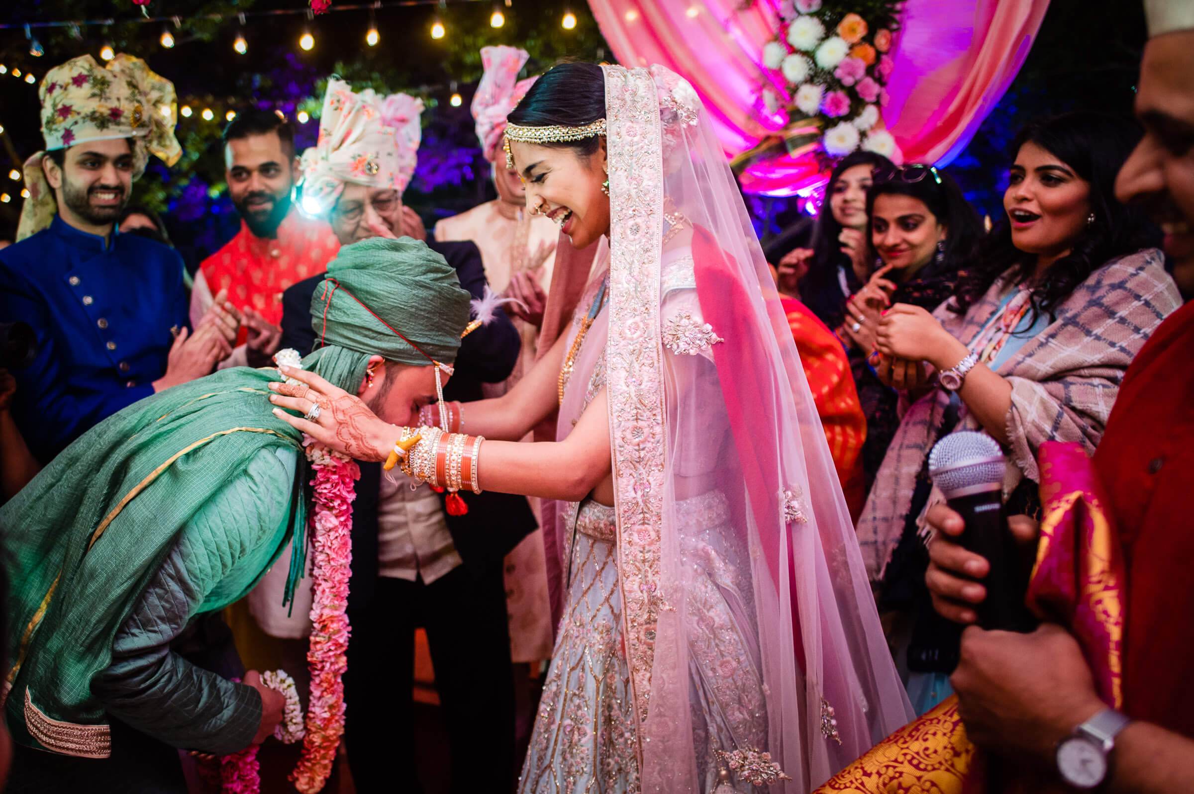 Shreya in pink bridal lehenga laughs while dancing with Yash in blue sherwani at colorful Mahabaleshwar wedding celebration