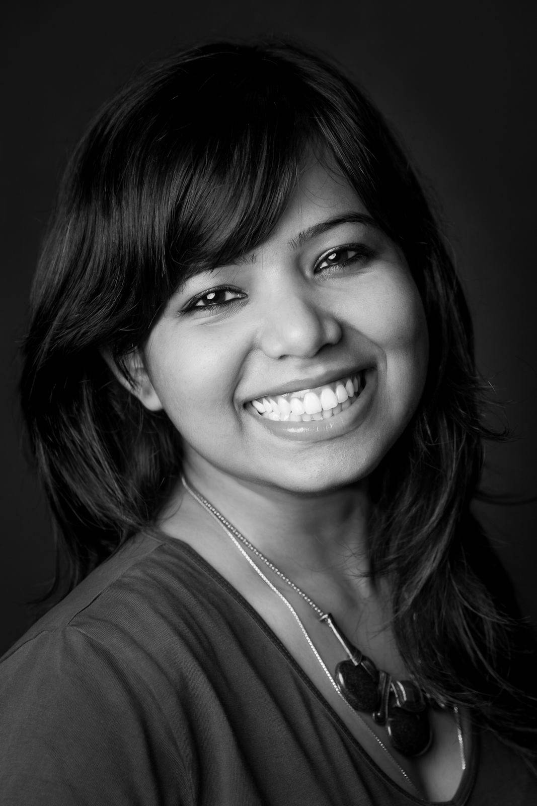 Black-and-white portrait of Rimi Sen, documentary wedding photographer, smiling