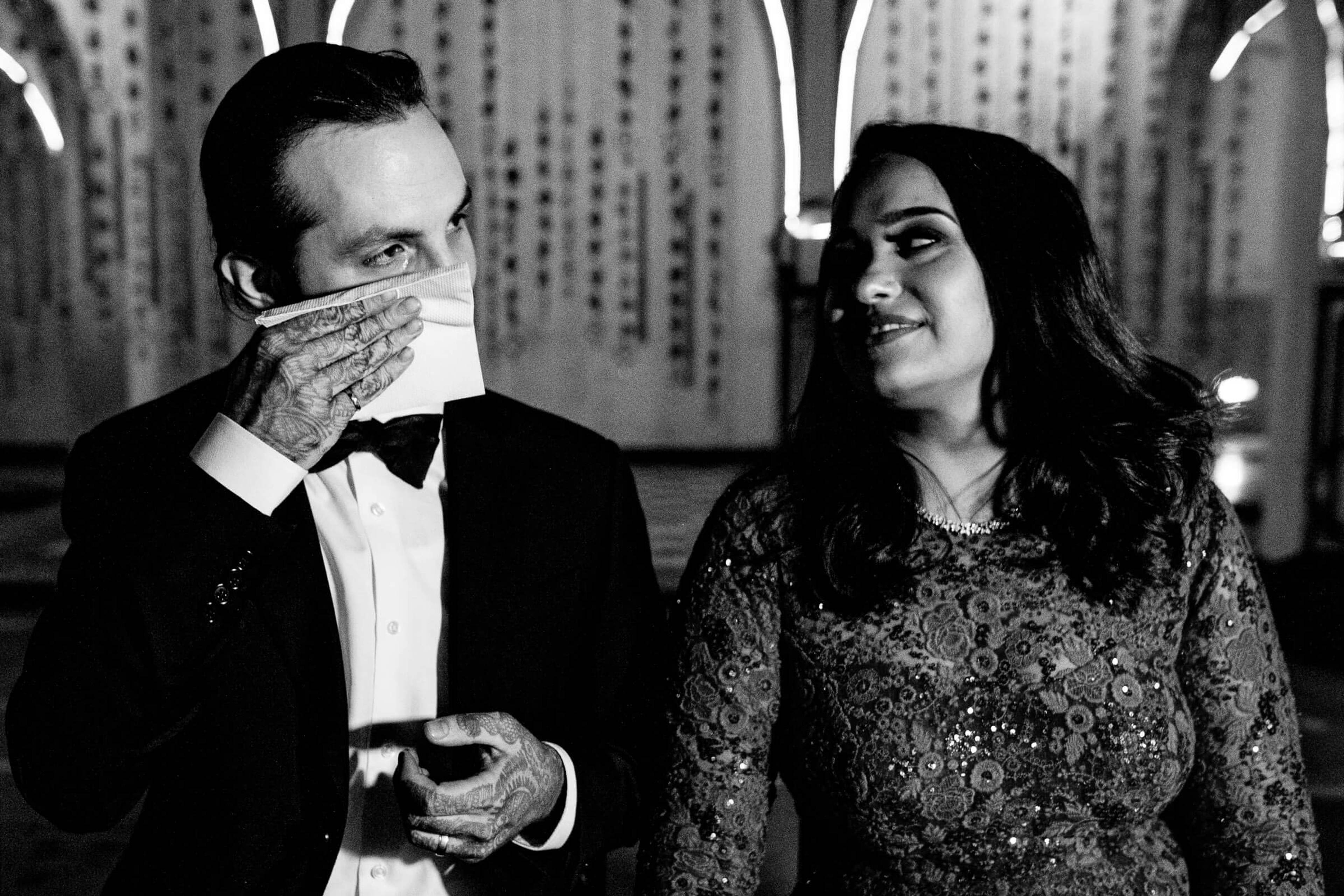 Maitrayee and Eric in formal attire at an illuminated venue, black and white portrait