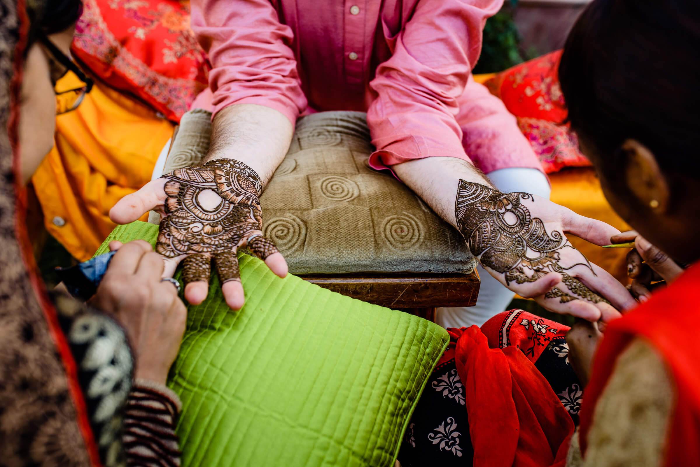 Maitrayee and Eric's hands with henna displaying intricate mehndi designs during Rajasthan wedding celebration