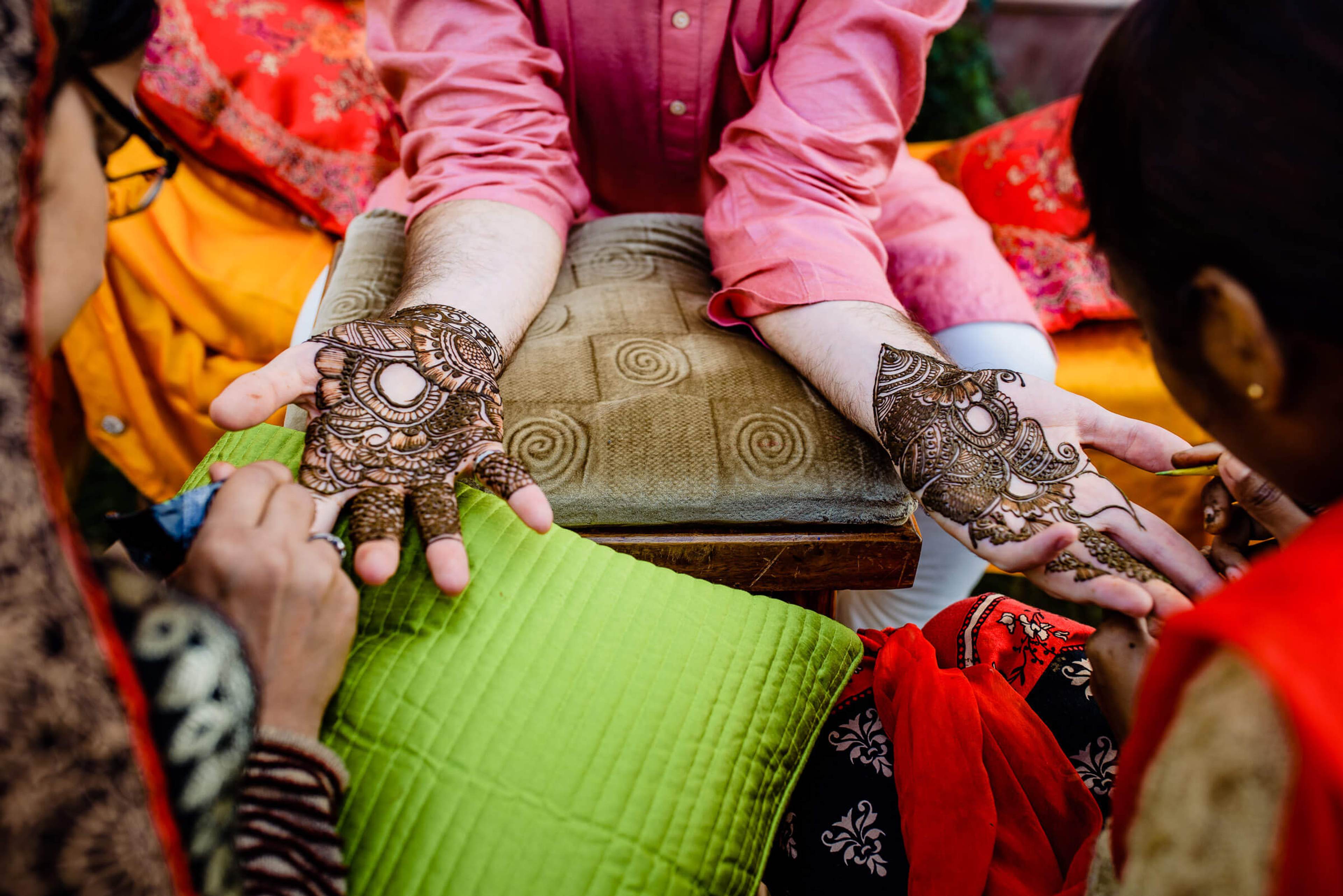 Maitrayee and Eric's hands with henna displaying intricate mehndi designs during Rajasthan wedding celebration