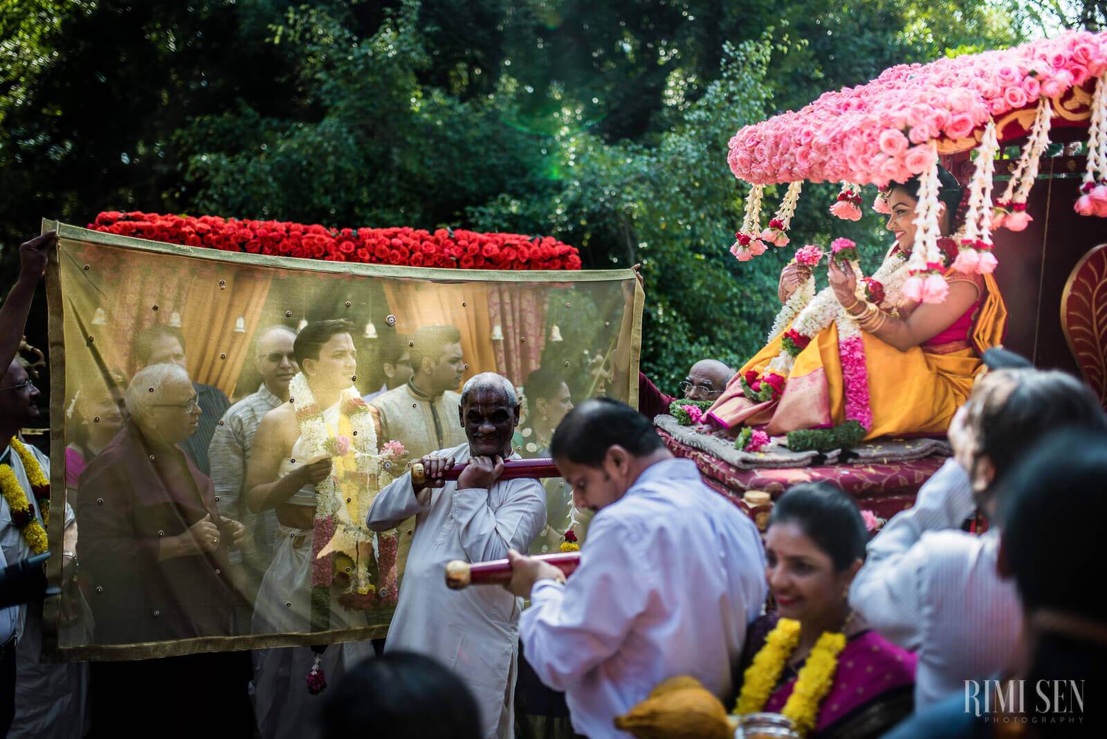 Pooja and Aniket's wedding ceremony in Bangalore with pink floral mandap and guests in traditional attire