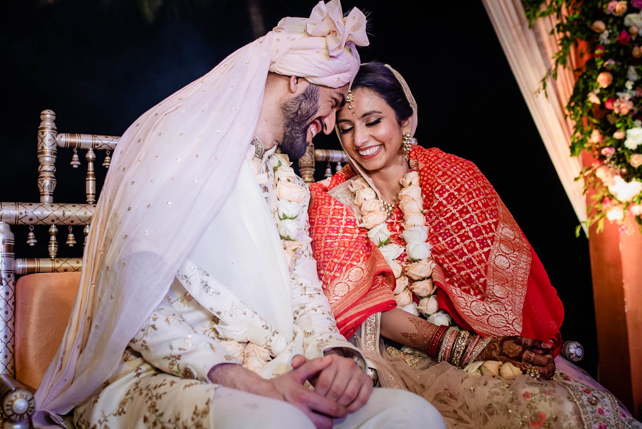 Avani and Srikant exchange intimate moment during traditional wedding ceremony in Goa, wearing ornate attire and flower garlands