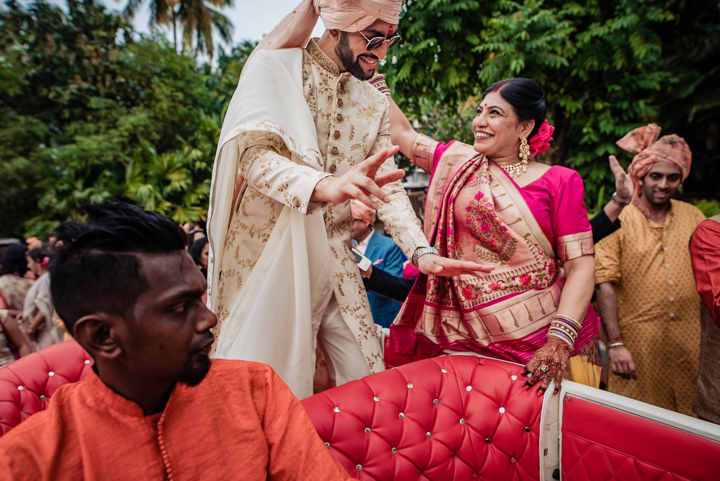 Avani and Srikant exchange rings in traditional wedding attire at a Goa celebration surrounded by family and guests