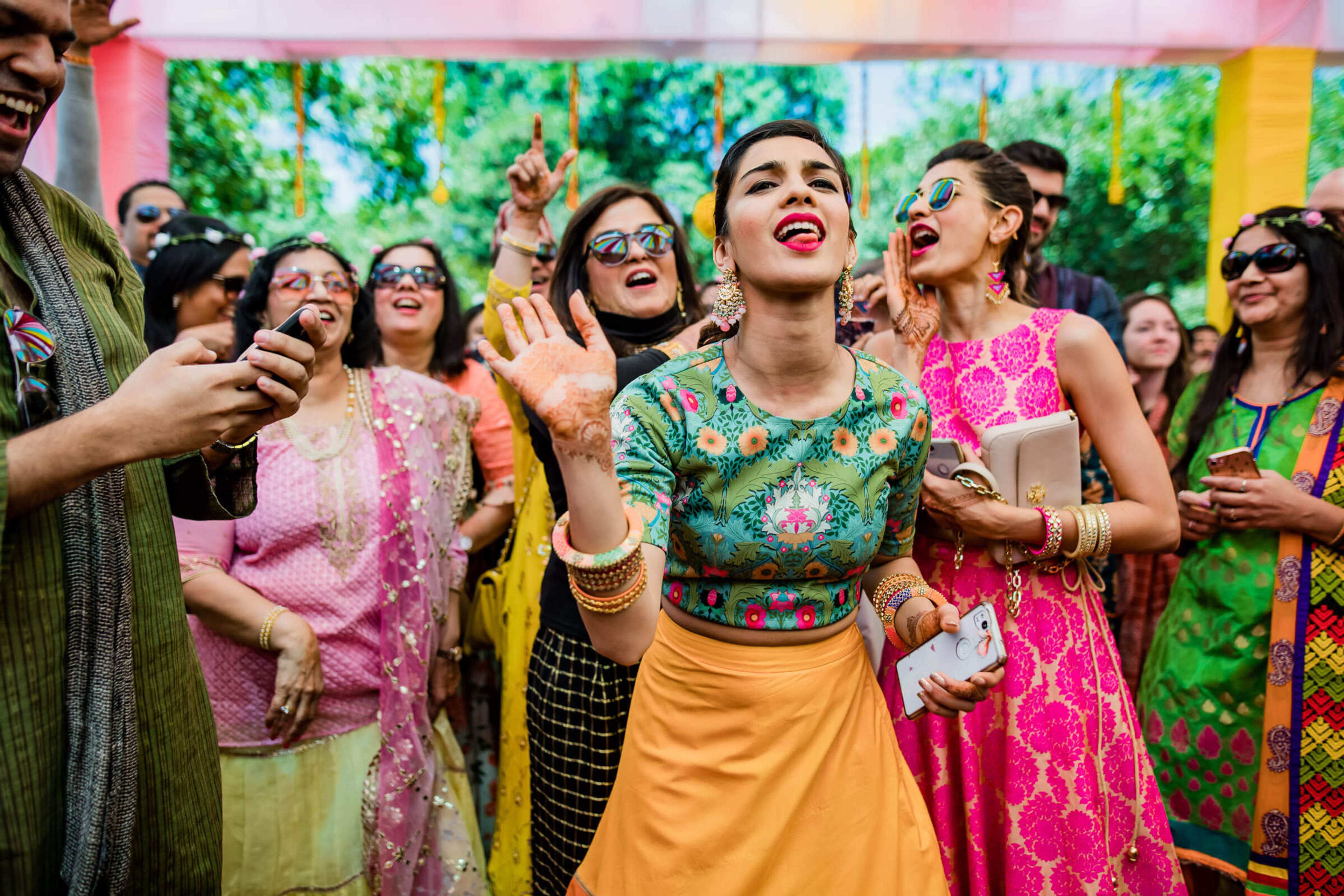 Shreya and Yash celebrate with colorful-dressed guests under vibrant pink and yellow décor at Mahabaleshwar