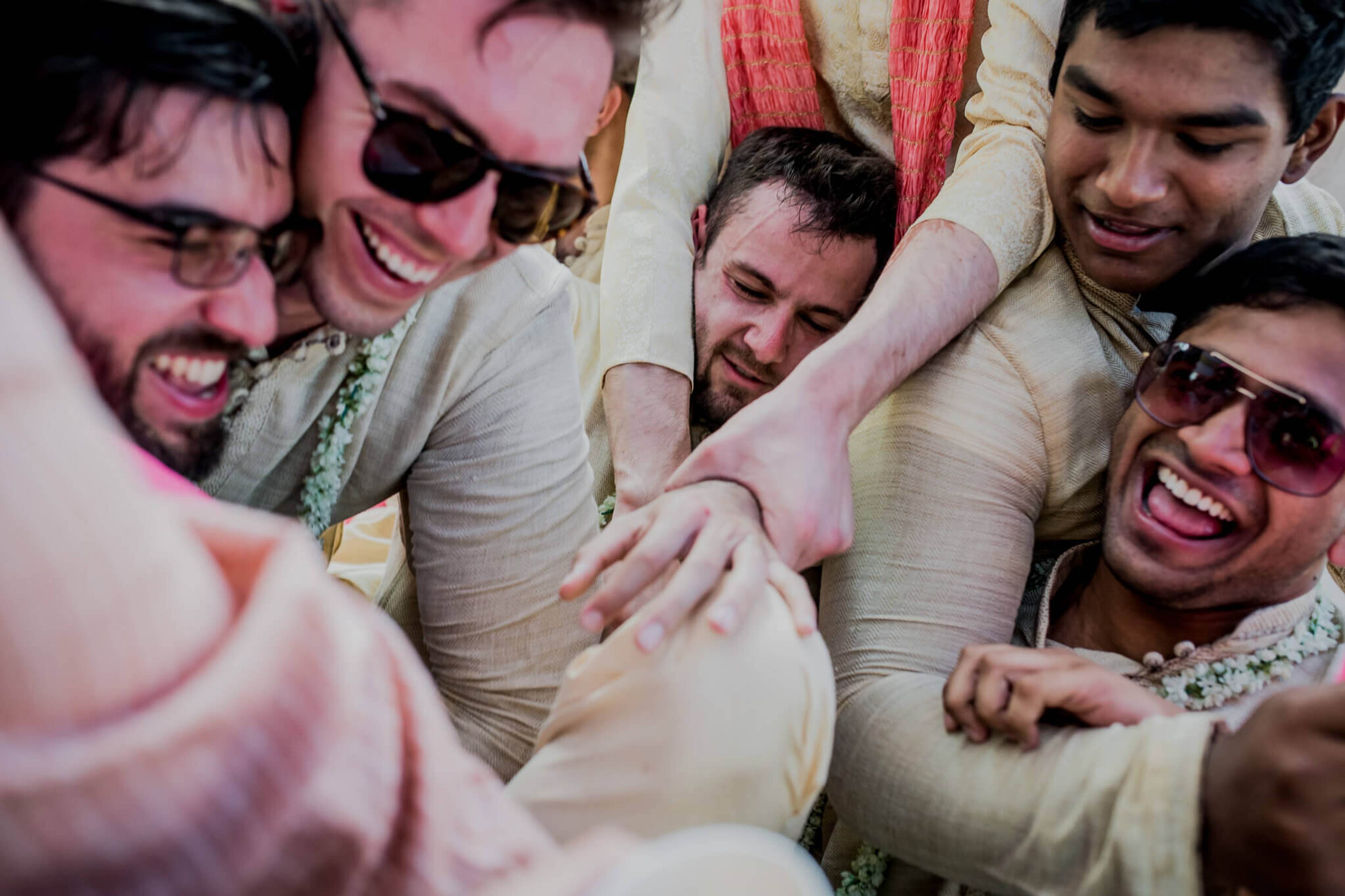 Anu and Raghu's wedding guests celebrate with linked arms and joyful smiles in Nepal
