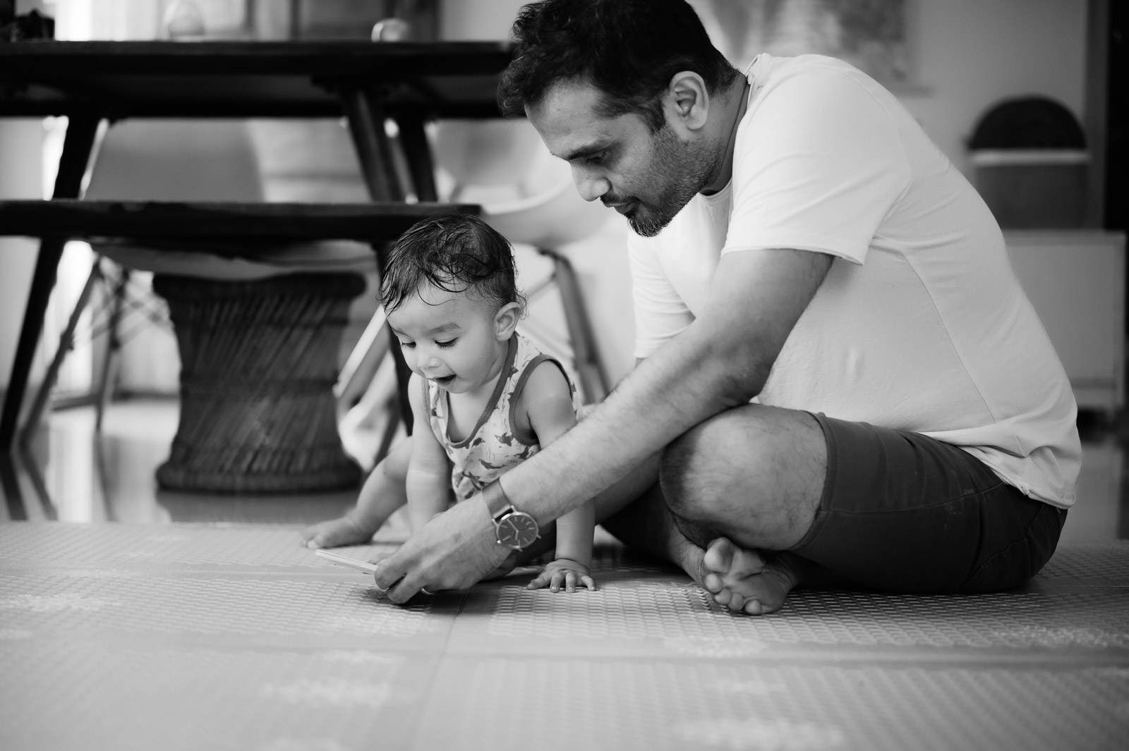 Man and toddler playing together on floor in black and white portrait