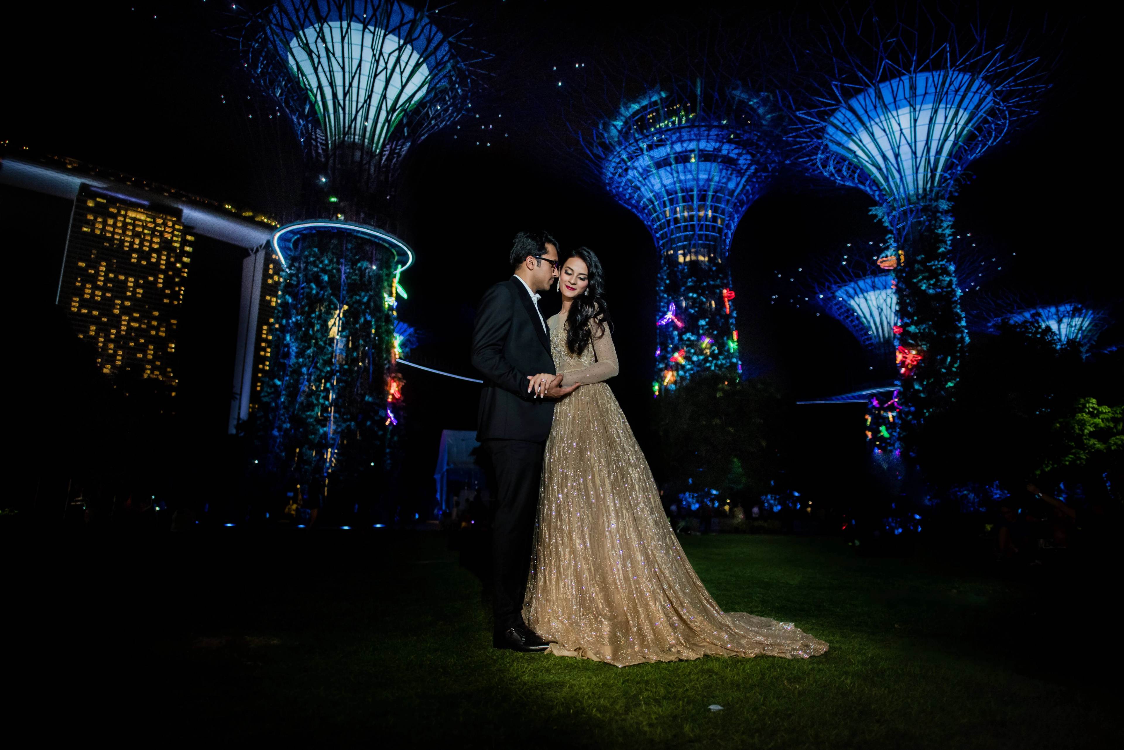 Yash and Disha embrace under illuminated supertrees at night in Singapore