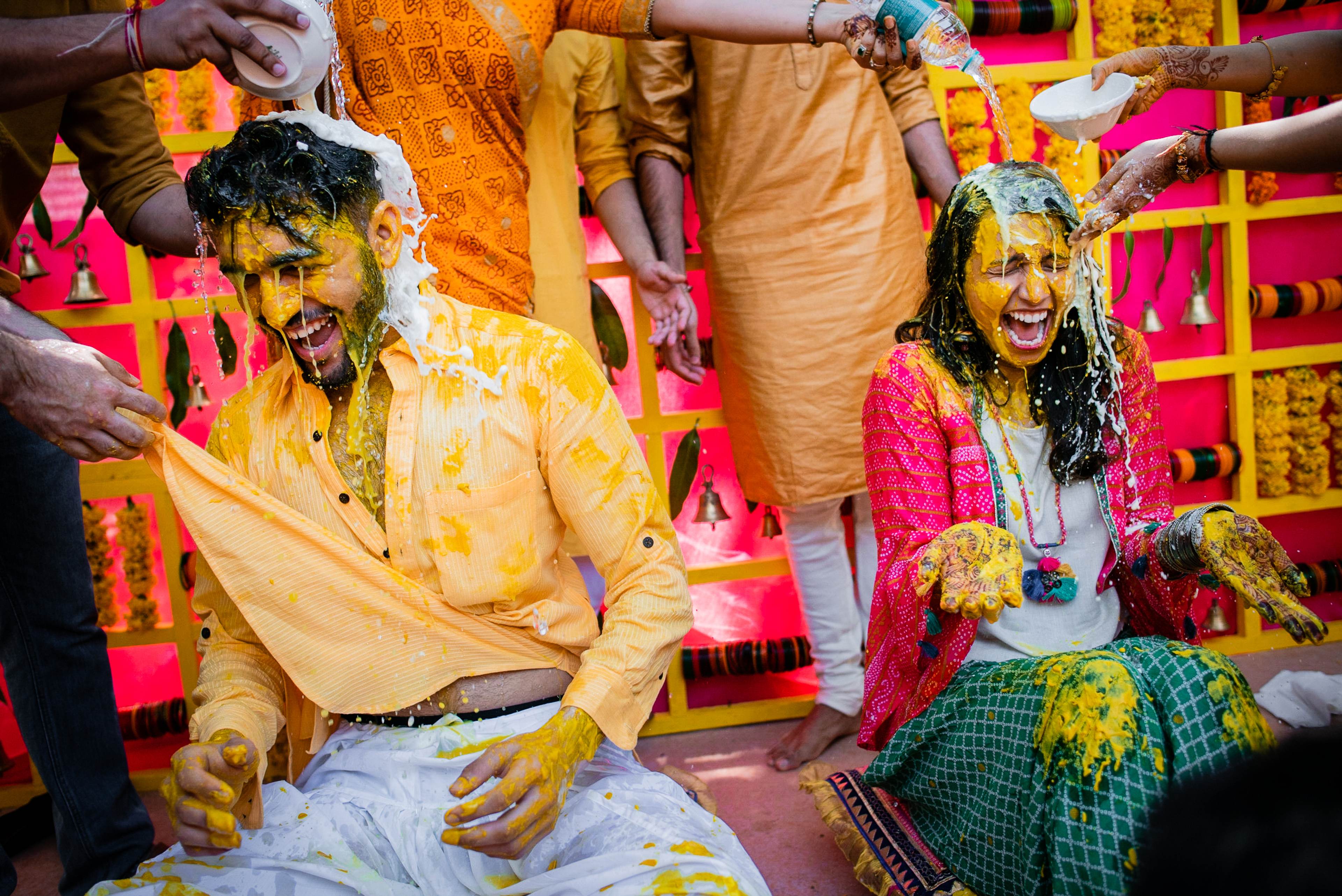 Avani and Srikant covered in yellow and green powder during vibrant Holi celebration in Goa
