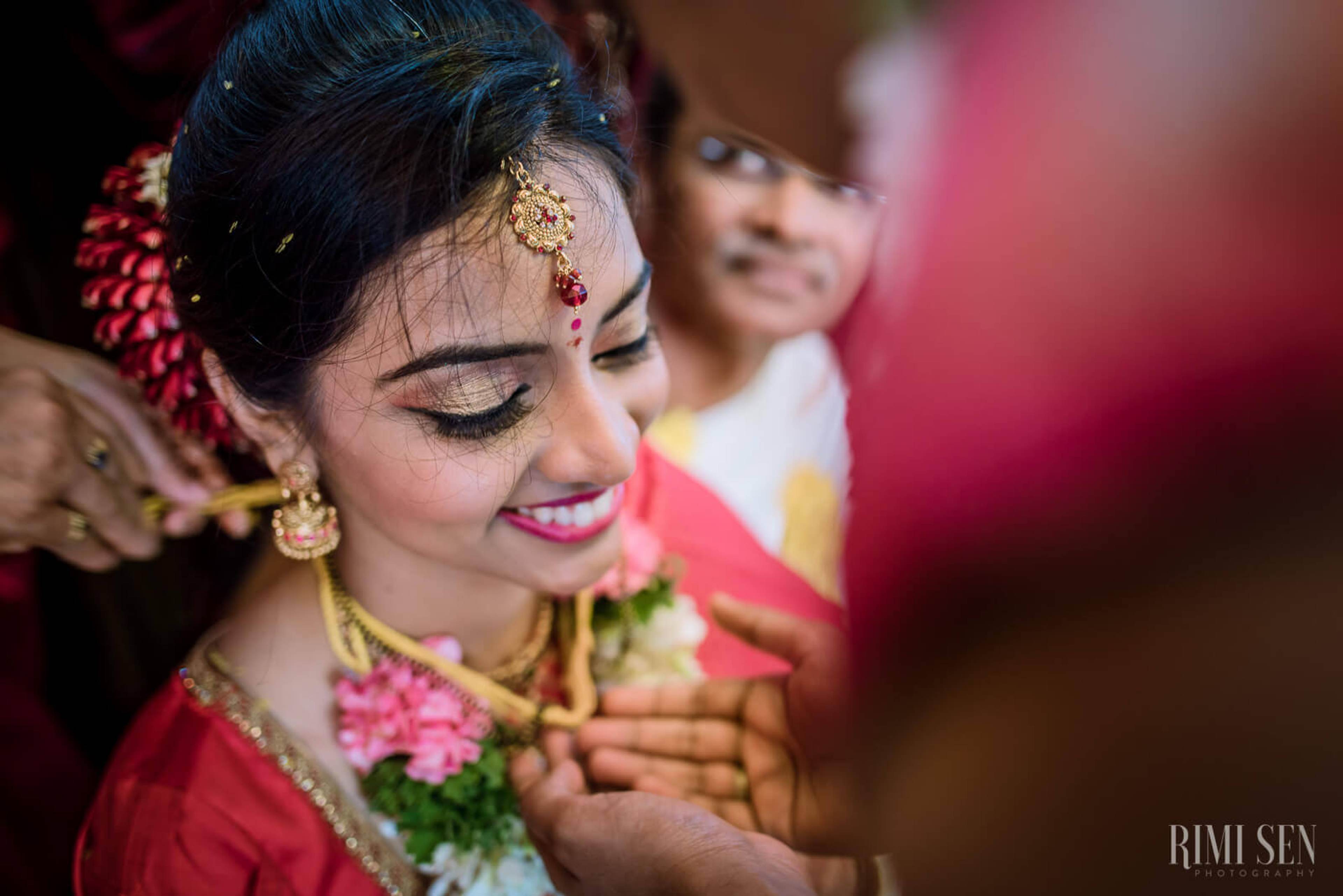 Pooja adorned in red bridal attire, gold jewelry, and traditional bindi at Bangalore wedding
