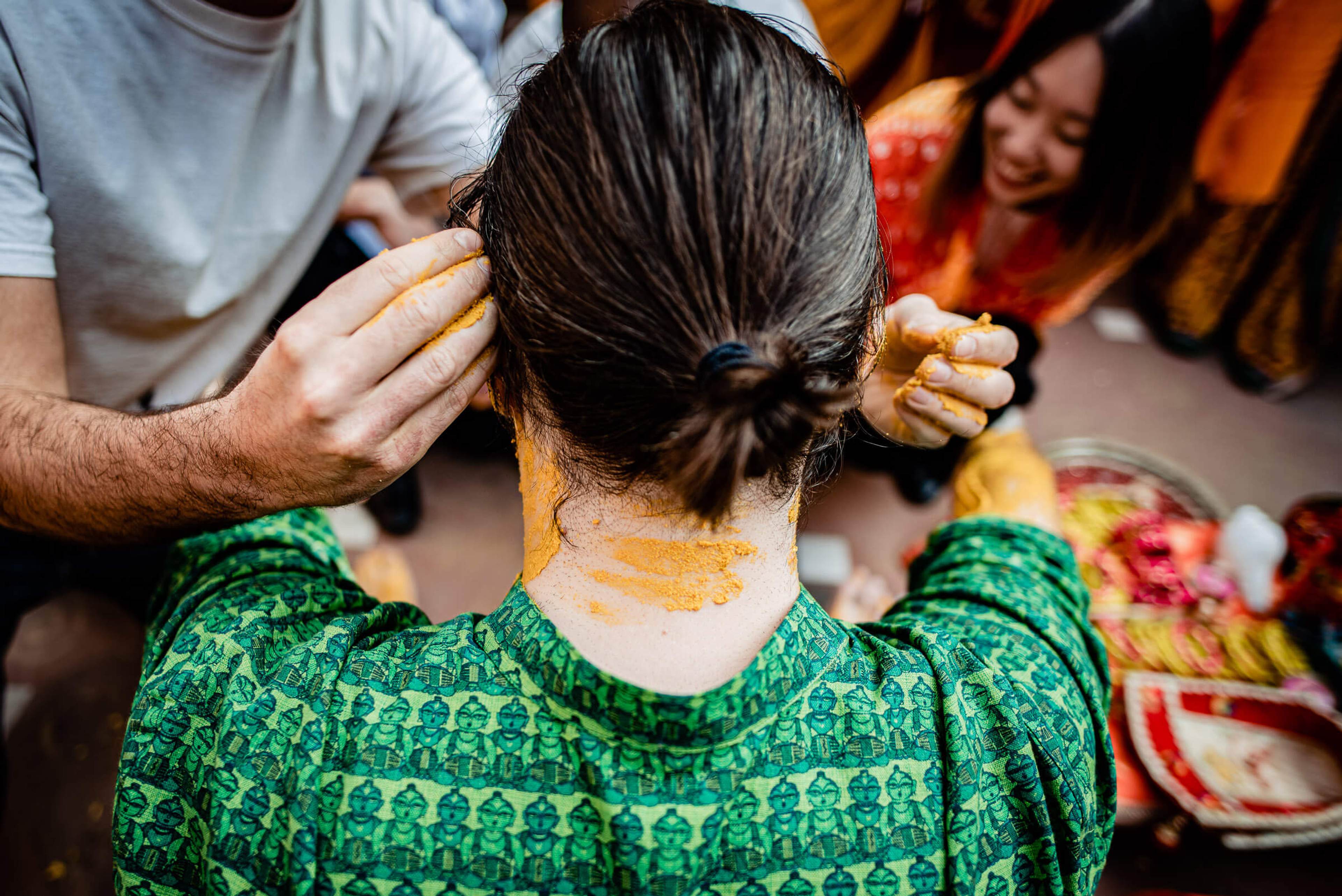 Maitrayee gets turmeric applied to her neck during a wedding celebration in Rajasthan