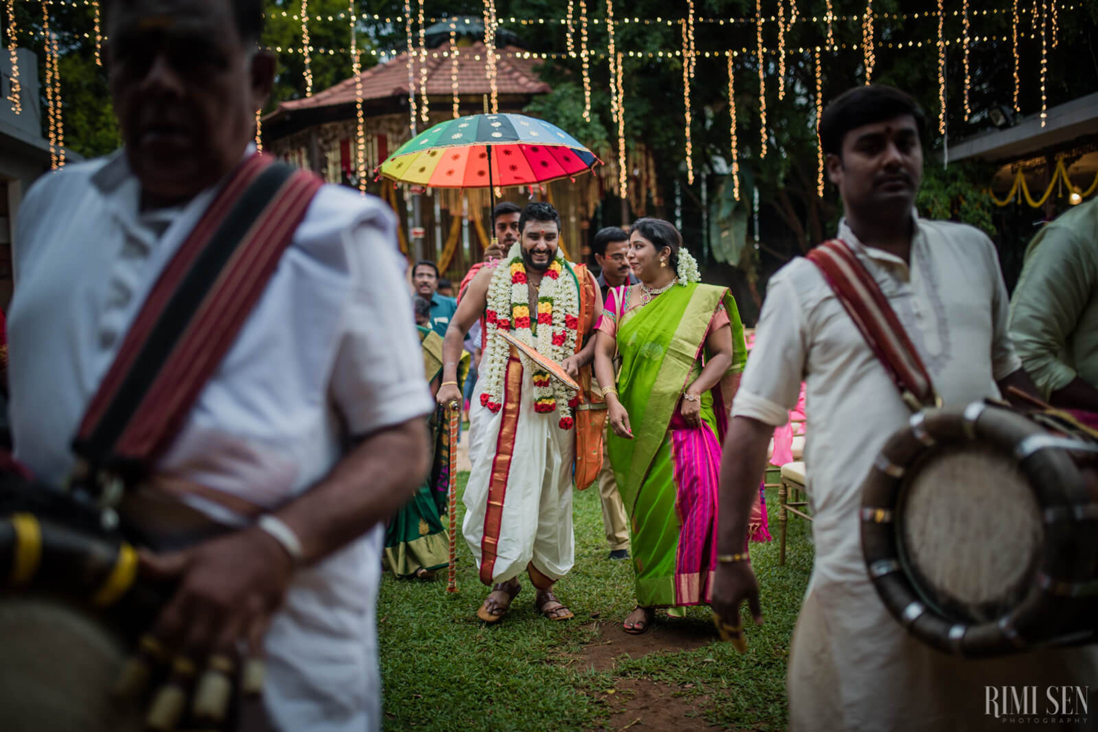 Nivetha and Sridhar exchange vows under rainbow umbrella in traditional attire at Bangalore wedding ceremony