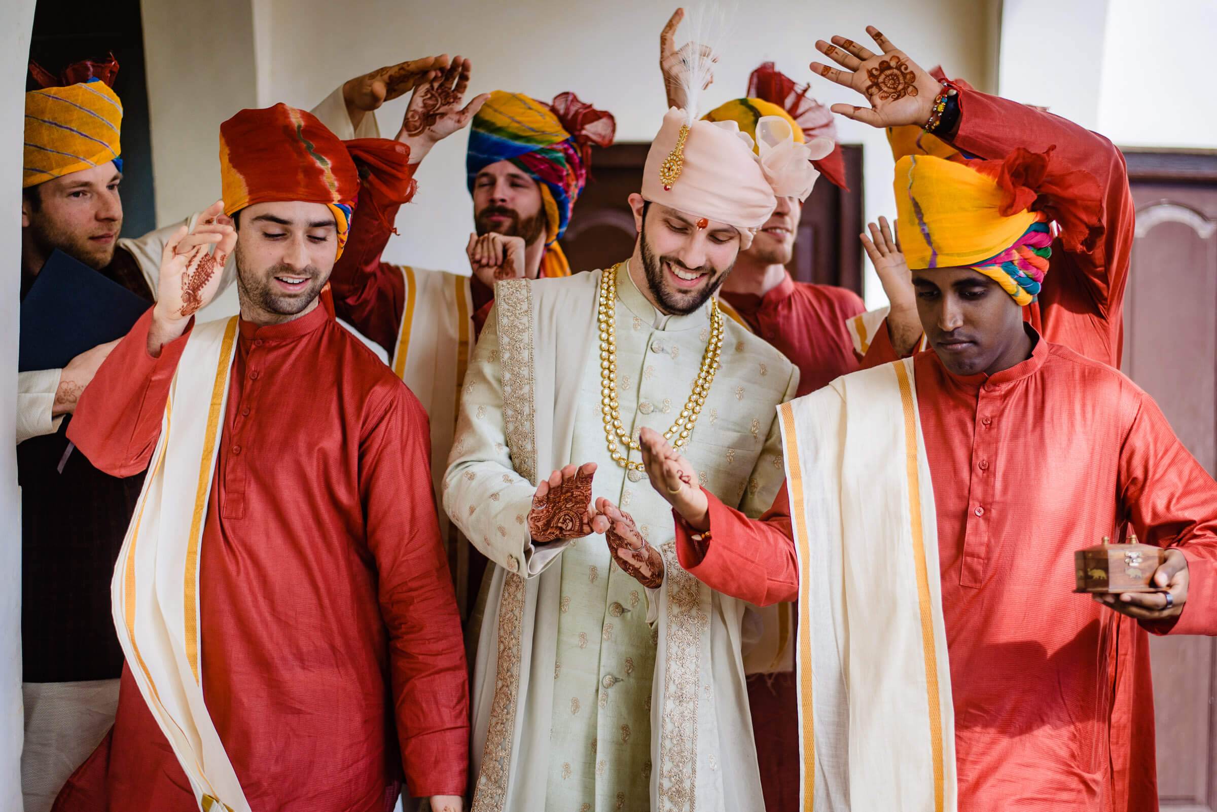 Maitrayee and Eric celebrate with family in traditional Rajasthani attire, displaying henna-adorned hands indoors