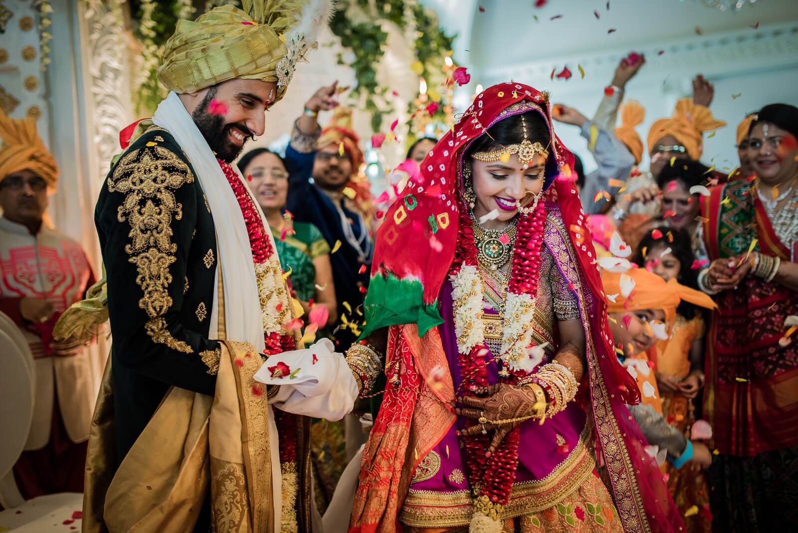 Barkha and Ankit exchange vows in traditional Indian wedding attire, surrounded by colorful confetti and celebrating guests in New York