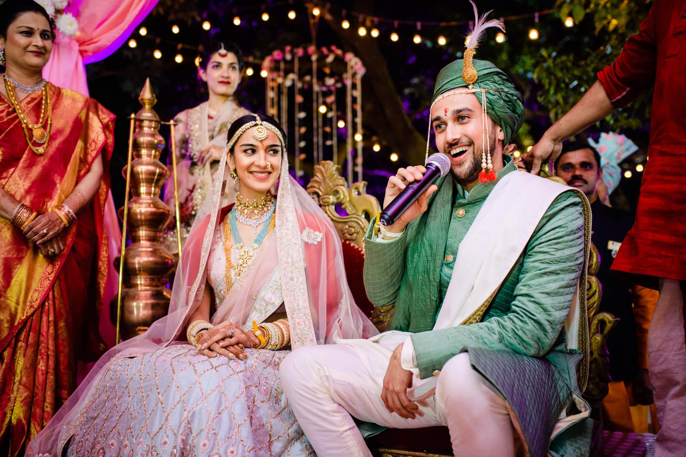 Shreya and Yash smile during their wedding ceremony at Mahabaleshwar, surrounded by festive lighting and guests