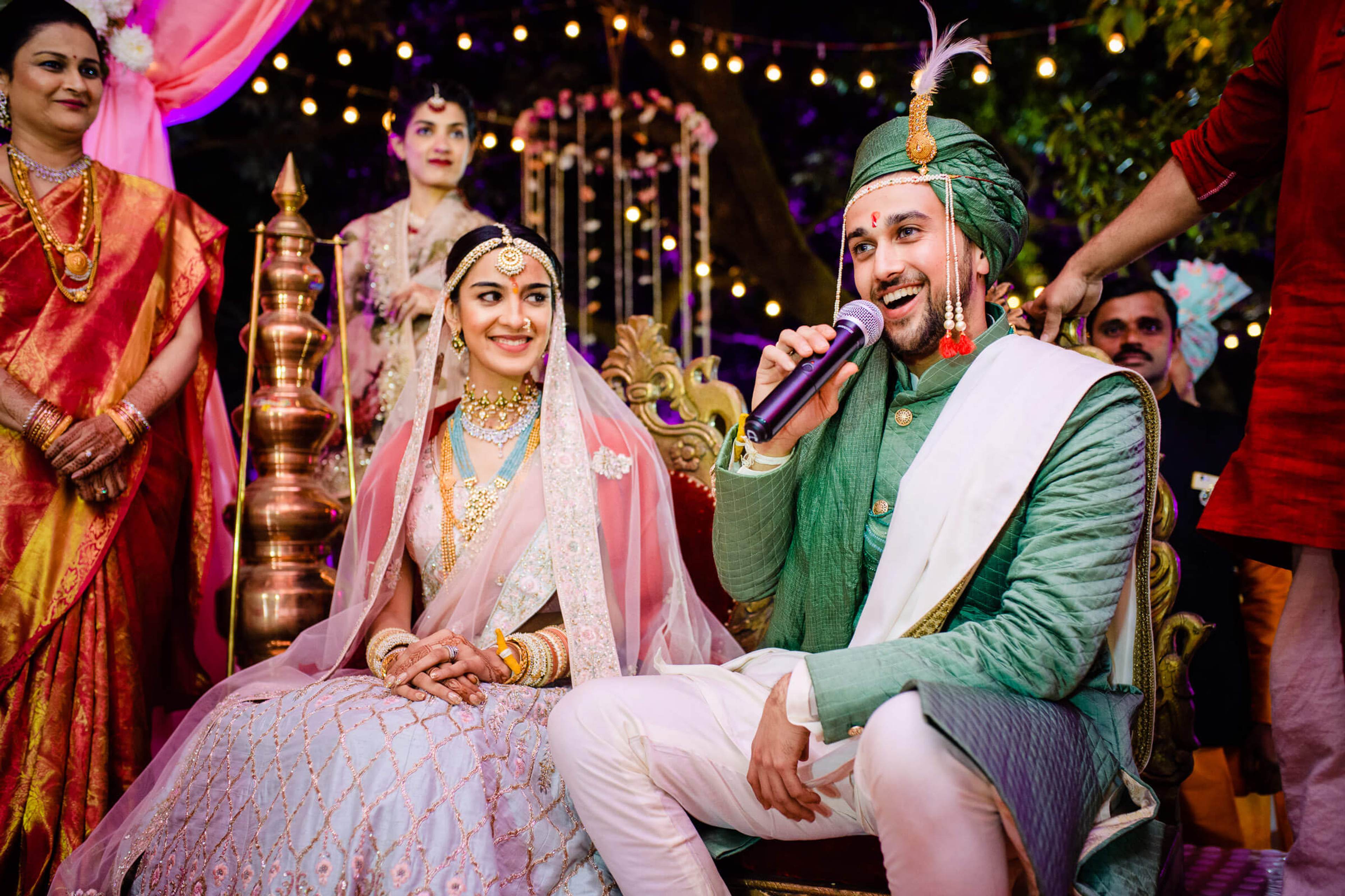 Shreya and Yash smile during their wedding ceremony at Mahabaleshwar, surrounded by festive lighting and guests
