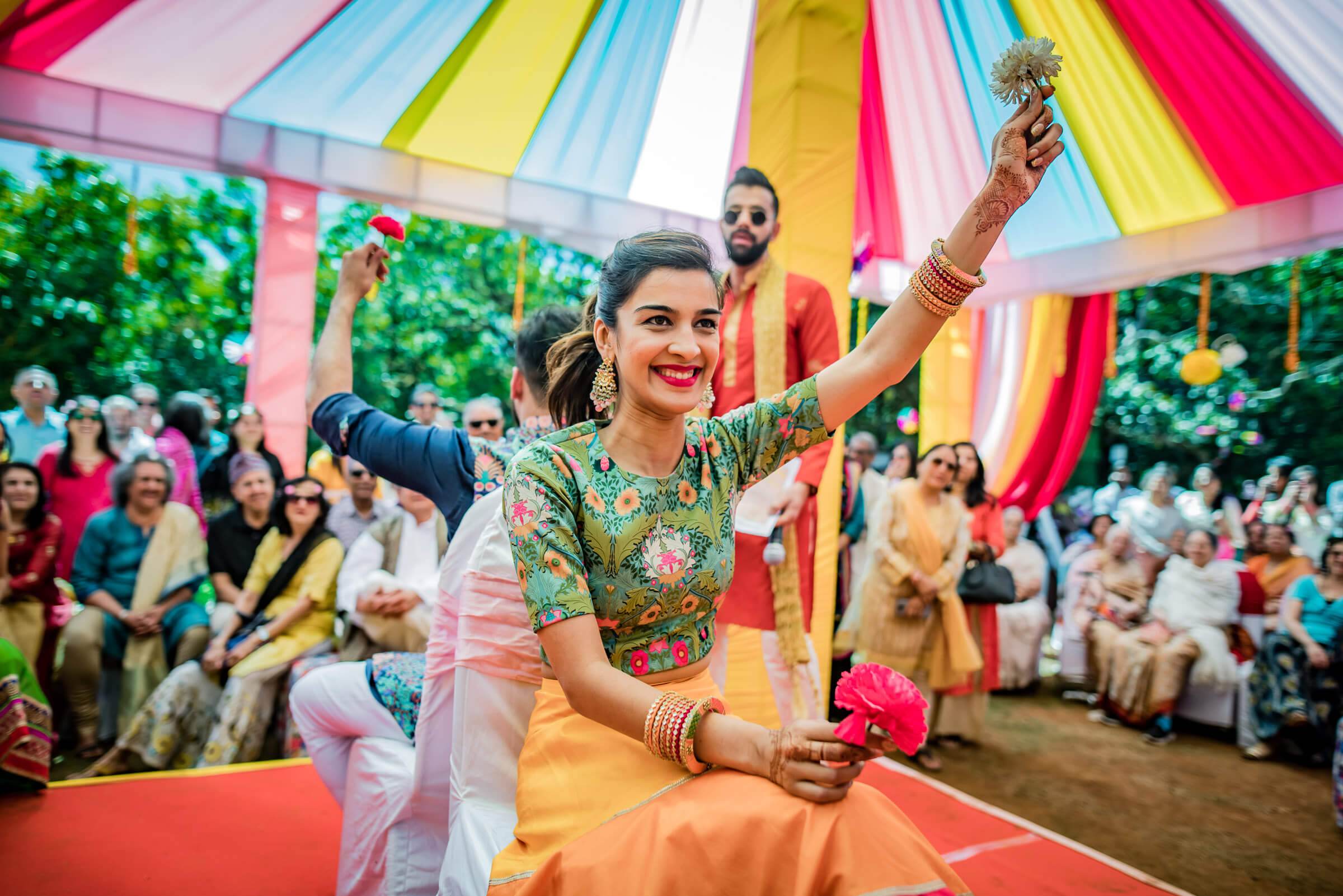 Shreya celebrates under colorful striped tent canopy at Mahabaleshwar wedding, guests gathered around