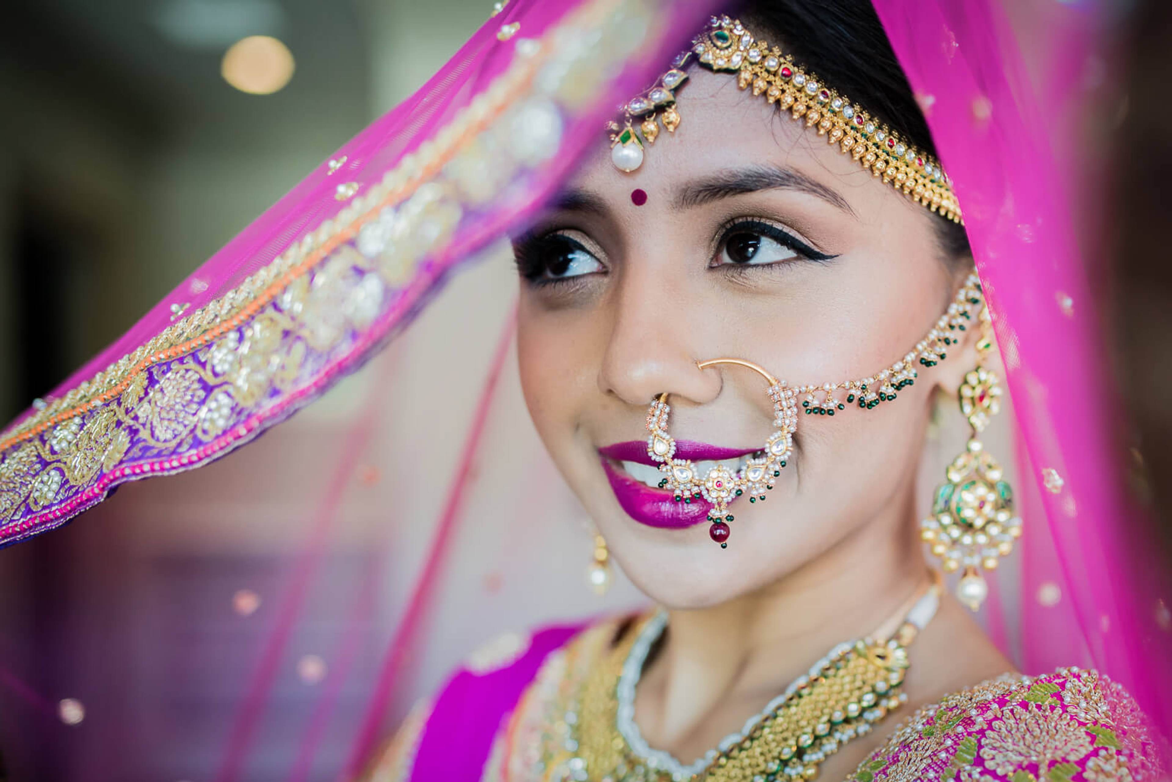 Barkha in vibrant pink bridal veil, ornate gold jewelry, and traditional Indian wedding attire in New York