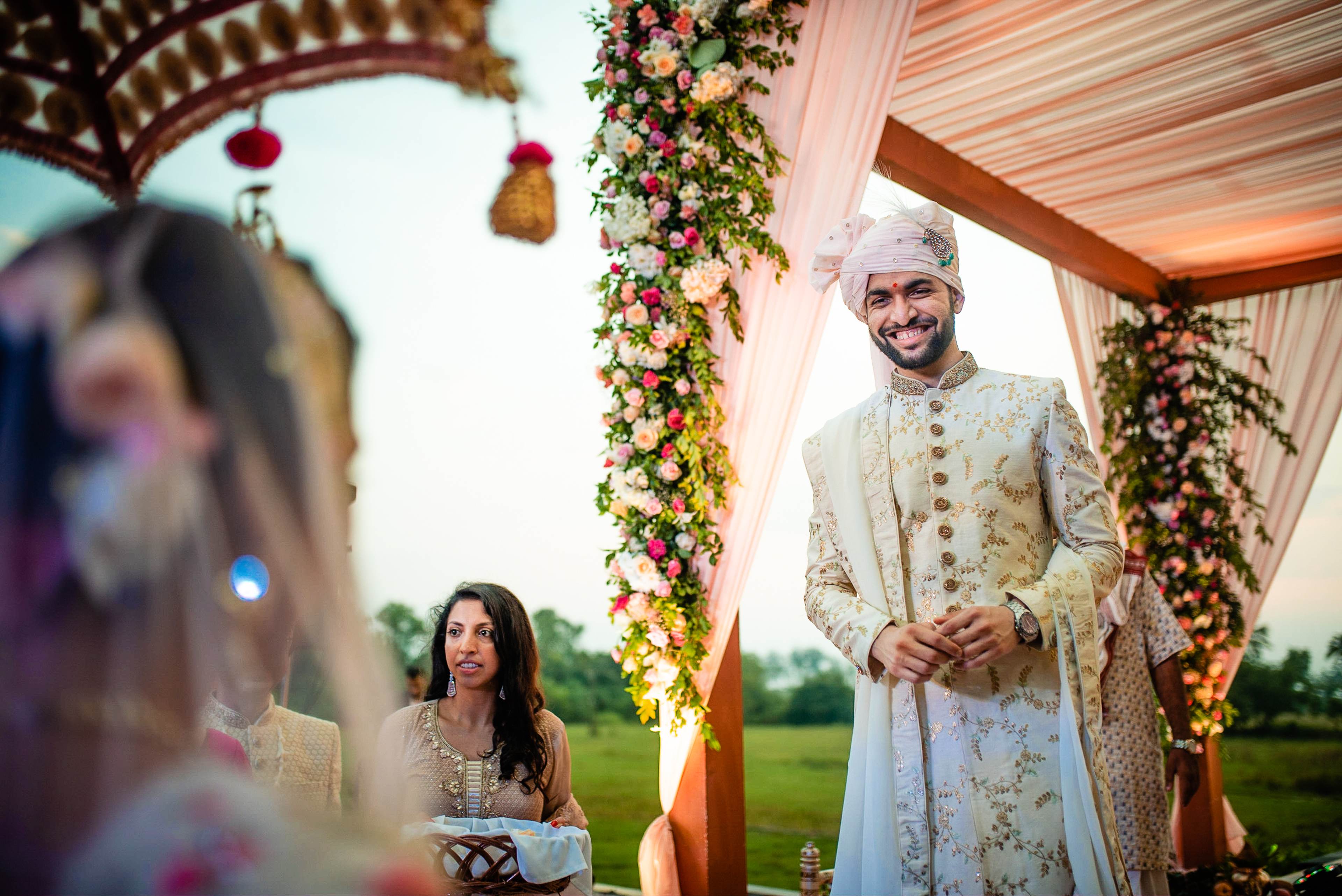 Avani and Srikant exchange vows under a floral mandap in Goa, surrounded by vibrant garland decorations