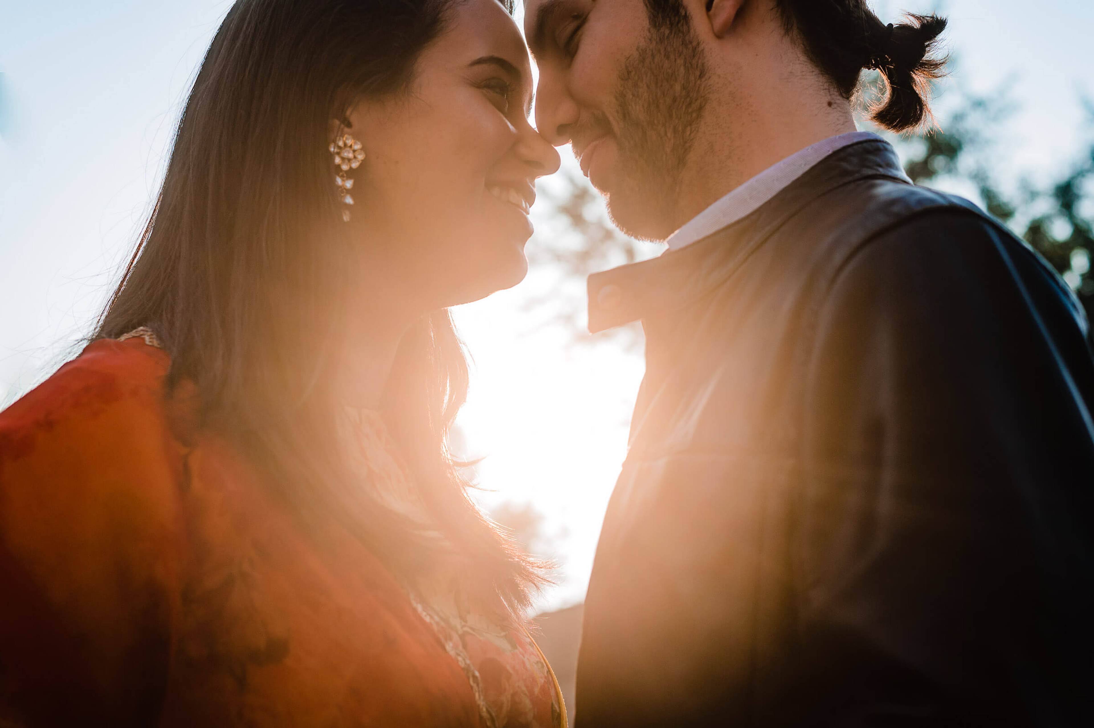 Maitrayee and Eric share an intimate moment in golden sunlight in Rajasthan, backlit and close